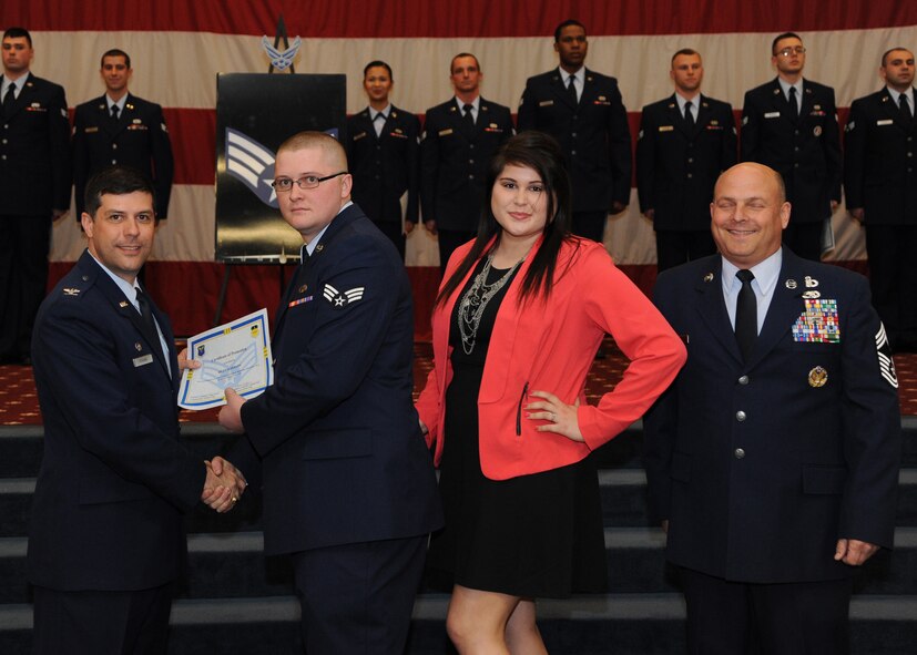 Senior Airman Riley Alderson, 2nd Munitions Squadron, receives a certificate of promotion from Col. Andrew Gebara, 2nd Bomb Wing commander, and Chief Master Sgt. Stephen Lebrun, 2nd Operations Group, during the February Wing Promotion Ceremony on Barksdale Air Force Base, La., Feb. 28, 2014. (U.S. Air Force photo/Senior Airman Joseph A. Pagán Jr.)