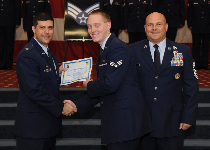 Senior Airman Anthony West, 2nd Maintenance Squadron, receives a certificate of promotion from Col. Andrew Gebara, 2nd Bomb Wing commander, and Chief Master Sgt. Stephen Lebrun, 2nd Operations Group, during the February Wing Promotion Ceremony on Barksdale Air Force Base, La., Feb. 28, 2014. (U.S. Air Force photo/Senior Airman Joseph A. Pagán Jr.)