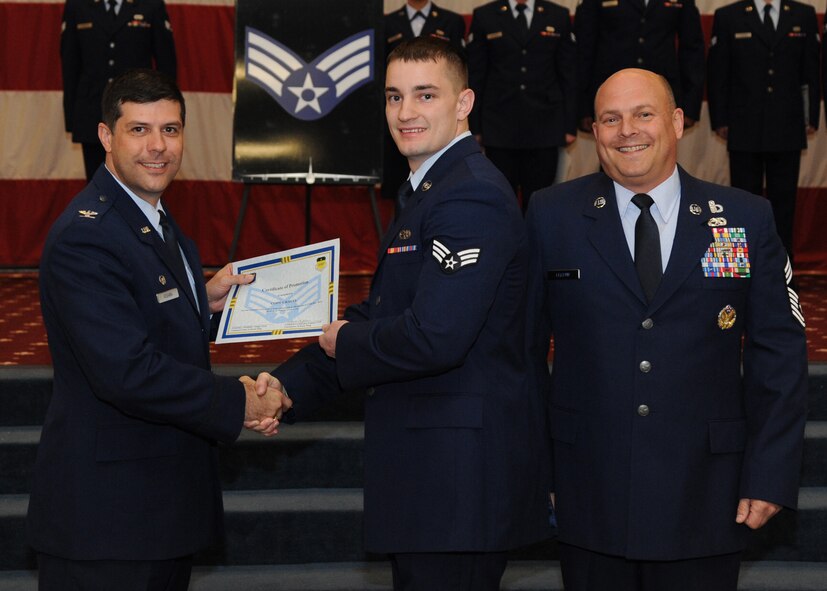 Senior Airman Cody Grauel, 2nd Maintenance Squadron, receives a certificate of promotion from Col. Andrew Gebara, 2nd Bomb Wing commander, and Chief Master Sgt. Stephen Lebrun, 2nd Operations Group, during the February Wing Promotion Ceremony on Barksdale Air Force Base, La., Feb. 28, 2014. (U.S. Air Force photo/Senior Airman Joseph A. Pagán Jr.)