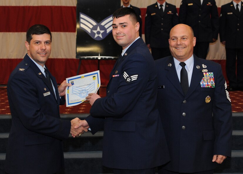 Senior Airman Matthew Brown, 2nd Maintenance Squadron, receives a certificate of promotion from Col. Andrew Gebara, 2nd Bomb Wing commander, and Chief Master Sgt. Stephen Lebrun, 2nd Operations Group, during the February Wing Promotion Ceremony on Barksdale Air Force Base, La., Feb. 28, 2014. (U.S. Air Force photo/Senior Airman Joseph A. Pagán Jr.)