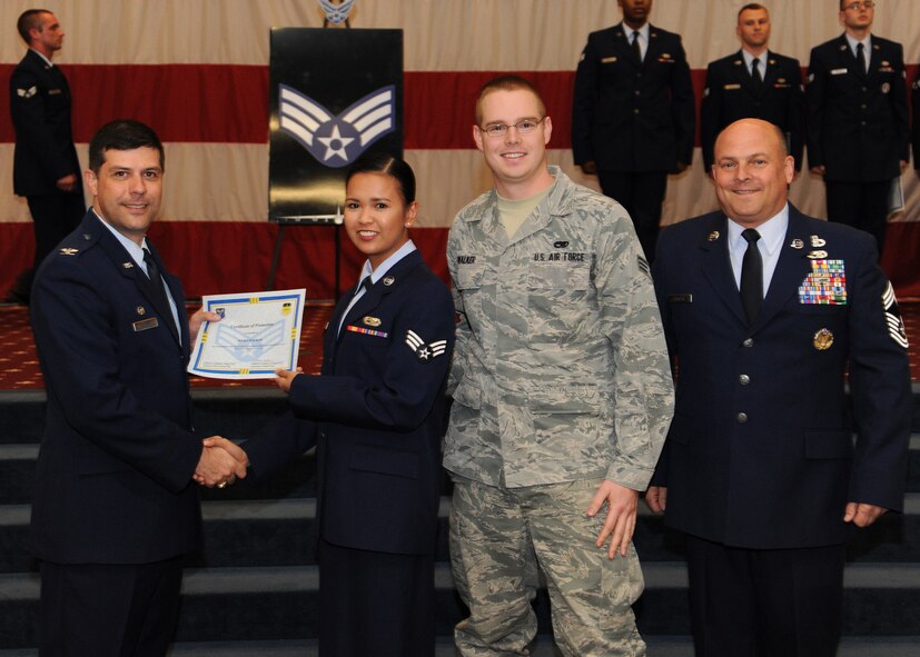 Senior Airman Myra Walker, 2nd Maintenance Group, receives a certificate of promotion from Col. Andrew Gebara, 2nd Bomb Wing commander, and Chief Master Sgt. Stephen Lebrun, 2nd Operations Group, during the February Wing Promotion Ceremony on Barksdale Air Force Base, La., Feb. 28, 2014. (U.S. Air Force photo/Senior Airman Joseph A. Pagán Jr.)