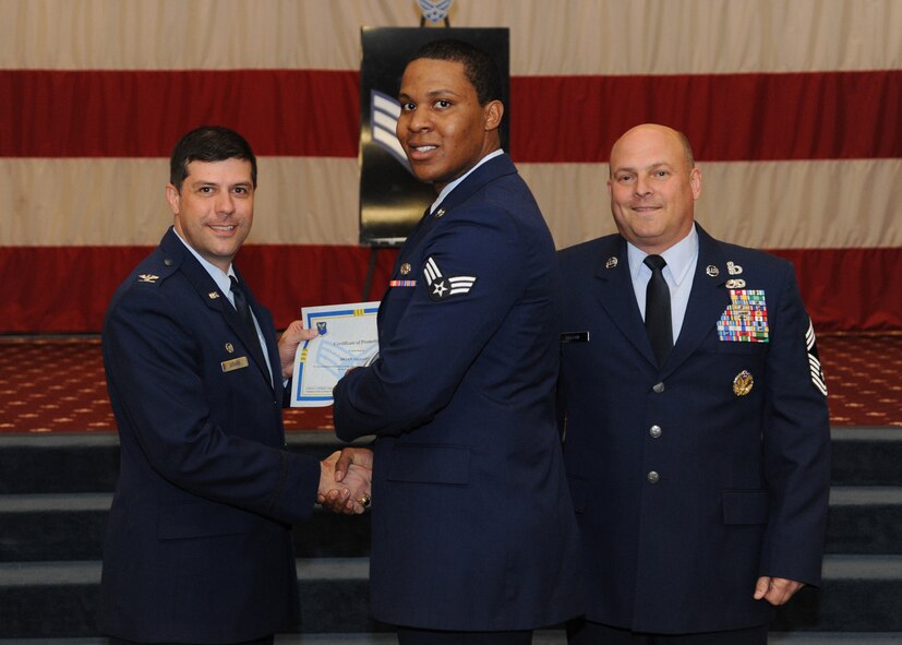 Senior Airman Bryan Siggers, 2nd Logistics Readiness Squadron, receives a certificate of promotion from Col. Andrew Gebara, 2nd Bomb Wing commander, and Chief Master Sgt. Stephen Lebrun, 2nd Operations Group, during the February Wing Promotion Ceremony on Barksdale Air Force Base, La., Feb. 28, 2014. (U.S. Air Force photo/Senior Airman Joseph A. Pagán Jr.)