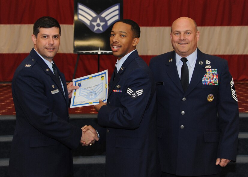 Senior Airman Philip Austin, 2nd Force Support Squadron, receives a certificate of promotion from Col. Andrew Gebara, 2nd Bomb Wing commander, and Chief Master Sgt. Stephen Lebrun, 2nd Operations Group, during the February Wing Promotion Ceremony on Barksdale Air Force Base, La., Feb. 28, 2014. (U.S. Air Force photo/Senior Airman Joseph A. Pagán Jr.)