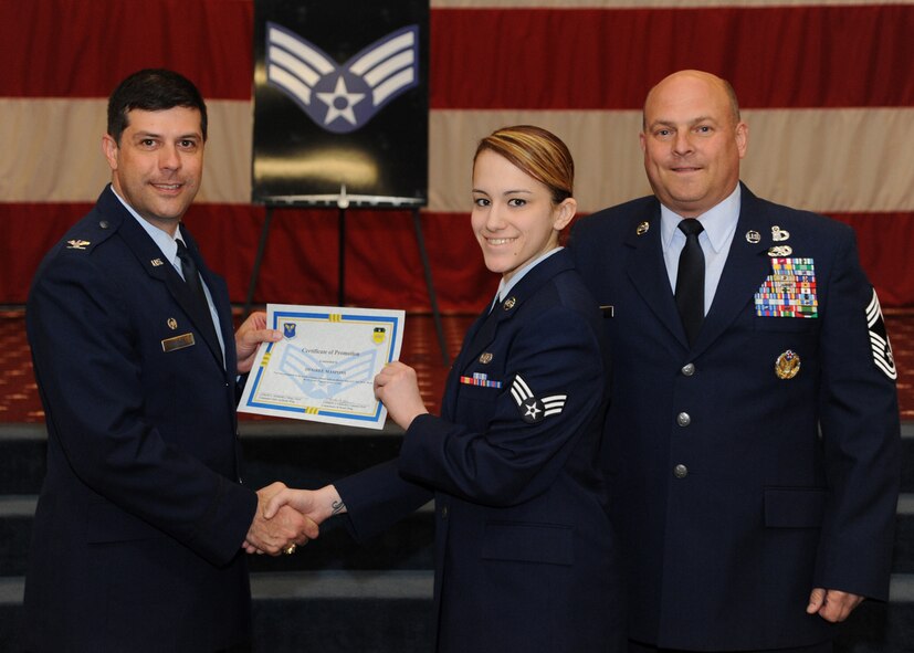 Senior Airman Desiree Maspons, 2nd Communications Squadron, receives a certificate of promotion from Col. Andrew Gebara, 2nd Bomb Wing commander, and Chief Master Sgt. Stephen Lebrun, 2nd Operations Group, during the February Wing Promotion Ceremony on Barksdale Air Force Base, La., Feb. 28, 2014. (U.S. Air Force photo/Senior Airman Joseph A. Pagán Jr.)