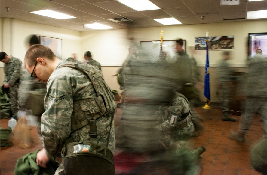 Airmen from the 5th Security Forces Squadron Delta Flight assemble their gear and depart their headquarters building at Minot Air Force Base, N.D. Jan. 30. The 5th SFS Delta and Charlie flights are in charge of providing security for the base during night shift while Alpha and Bravo cover daylight shifts. All four flights often work an average of 15 to 17 hours a day including guard mount and equipment issues. (U.S. Air Force photo/Senior Airman Stephanie Sauberan)