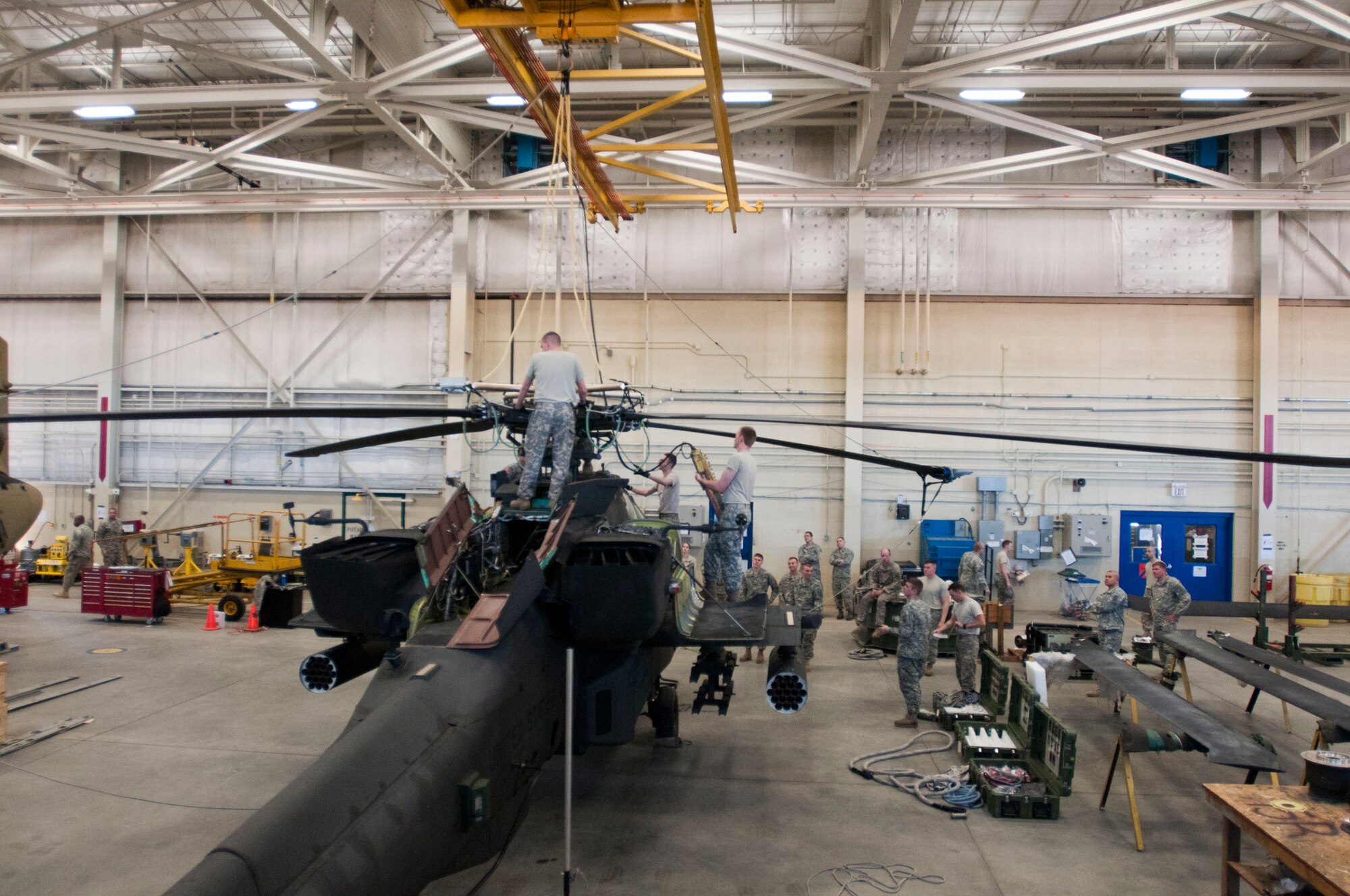 82nd Combat Aviation BrigadeSoldiers use the hoist in their hangar to suspend the cables of the  Unit Maintenance Aerial Recovery Kit they and Airmen from Pope Army Airfield helped assemble to an AH-64 Apache helicopter at Simmons Army Airfield, Feb. 24. Soldiers from 122nd  Aviation Support Battalion and 1-82 Attack Reconnaissance Battalion, and Airmen from 440th Maintenance Group and 2nd Airlift Squadron, 43rd Airlift Group, practiced using the Unit Maintenance Aerial Recovery Kit on an AH-64 Apache helicopter. DART and CDDAR teams are responsible for recovering aircraft after they crash or become disabled and can no longer fly. (Photo by U.S. Army Staff Sgt. April Campbell, 82nd Combat Aviation Brigade Public Affairs)