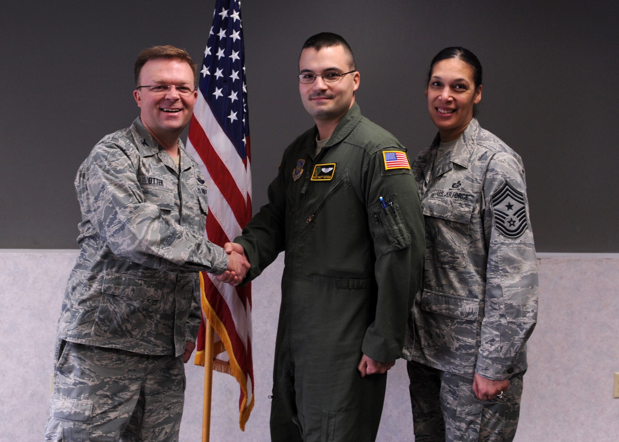 Col. William Otter, 19th Airlift Wing vice commander, along with Chief Master Sgt. Margarita Overton, 19th Airlift Wing command chief, congratulate Staff Sgt. Matthew Derda, a 34th Combat Training Squadron instructor loadmaster, for his selection as the Combat Airlifter of the Week March 4, 2014, at Little Rock Air Force Base, Ark. Derda, an  Athens, Ga., native, supported contingency operations in Southwest Asia, where he flew 50 combat missions delivering more than 1,800 passengers and over 2.2 million pounds of cargo. (U.S. Air Force photo by Airman 1st Class Scott Poe)