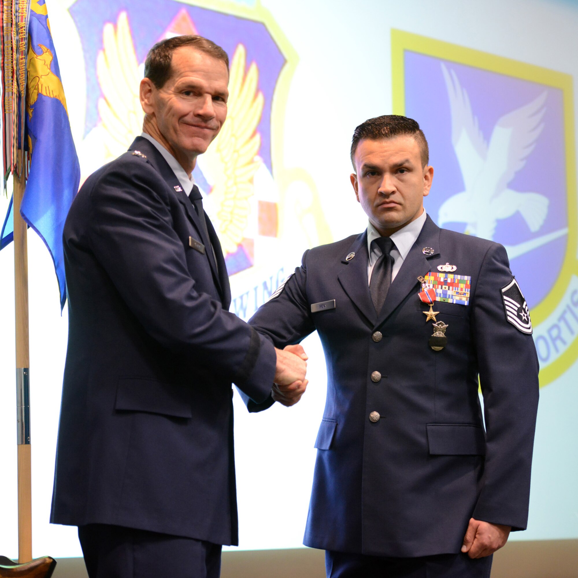 Director of the Air National Guard, U.S. Air Force Lt General Stanley E. Clark, III congratulates Master Sgt. Jose Pena-Rojas, 105th Base Defense Squadron, New York Air National Guard, who just received a Bronze Star medal during an awards ceremony at Stewart Air National Guard Base, N.Y. March 2, 2014.  (U.S. Air National Guard photo by Tech. Sgt. Michael OHalloran/Released)