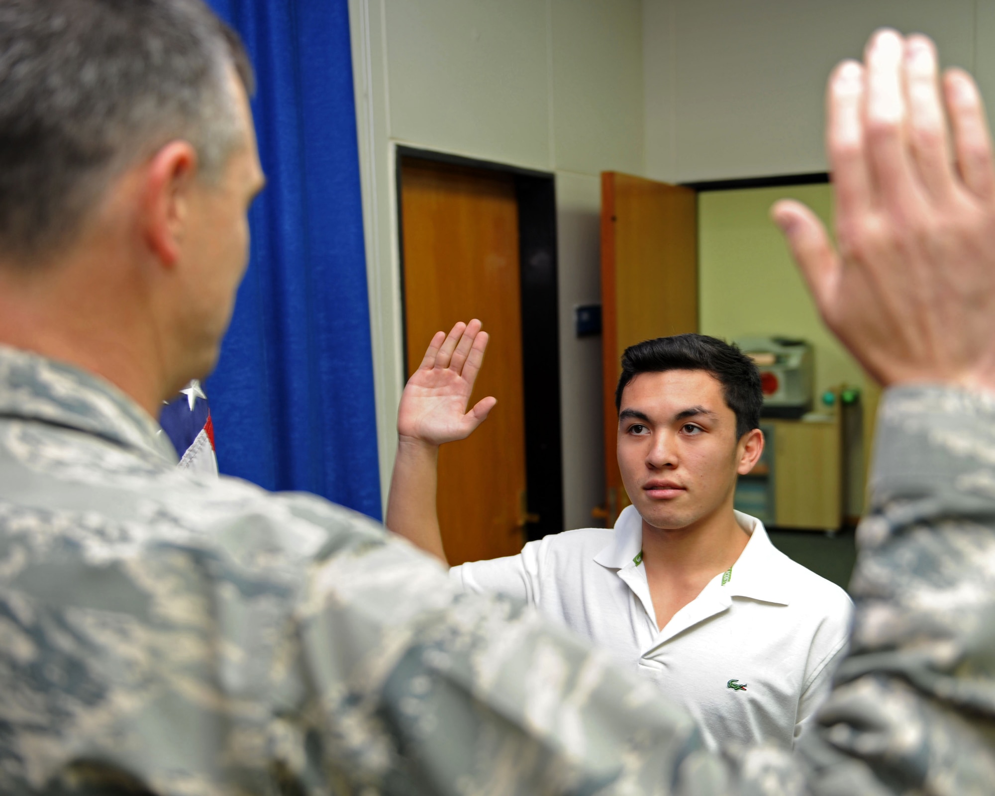Ruben Gawan, son of Chief Master Sgts. Lori and Phillip Gawan, takes the oath of enlistment Nov. 2, 2013, Incirlik Air Base, Turkey.  After 19 years of traveling around the globe with his parents as a military dependent he has decided to enlist in the Air Force. (U.S. Air Force photo by Senior Airman Chase Hedrick/Released) 