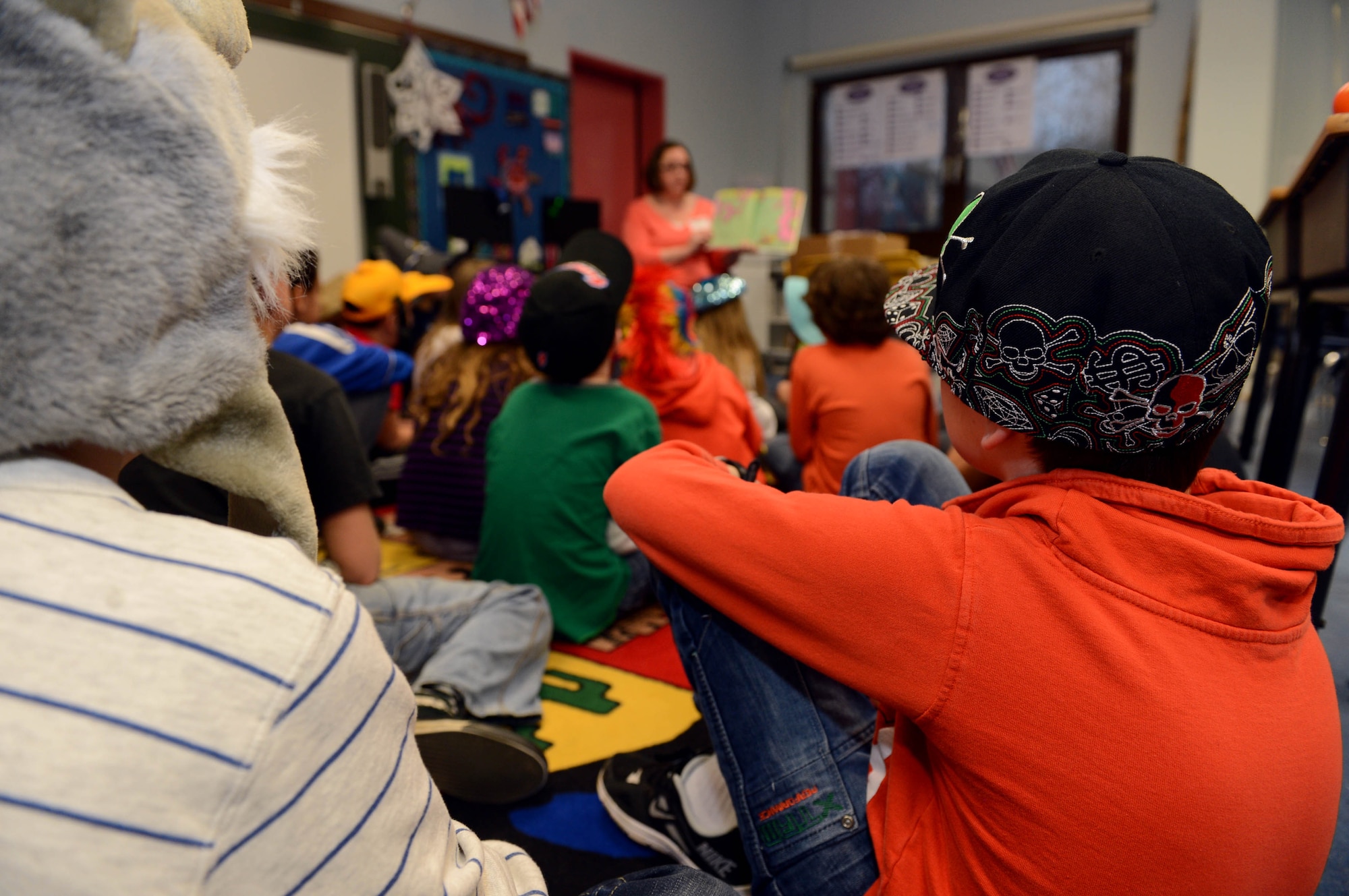 Spangdahlem Elementary students listen to a volunteer read a Dr. Seuss book during a Read Across America event at Spangdahlem Air Base, Germany, March 3, 2014. National Read Across America began in 1998 when the National Education Association pushed for a day to celebrate reading. (U.S. Air Force photo by Airman 1st Class Kyle Gese/Released)
