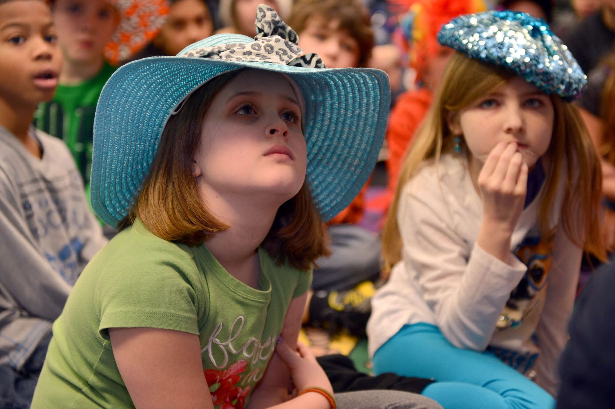 Hannah Sweazey, Spangdahlem Elementary student, listens to a volunteer read a Dr. Seuss book during a Read Across America event at Spangdahlem Air Base, Germany, March 3, 2014. National Read Across America is a day that celebrates the birthday of Dr. Seuss. (U.S. Air Force photo by Airman 1st Class Kyle Gese/Released)