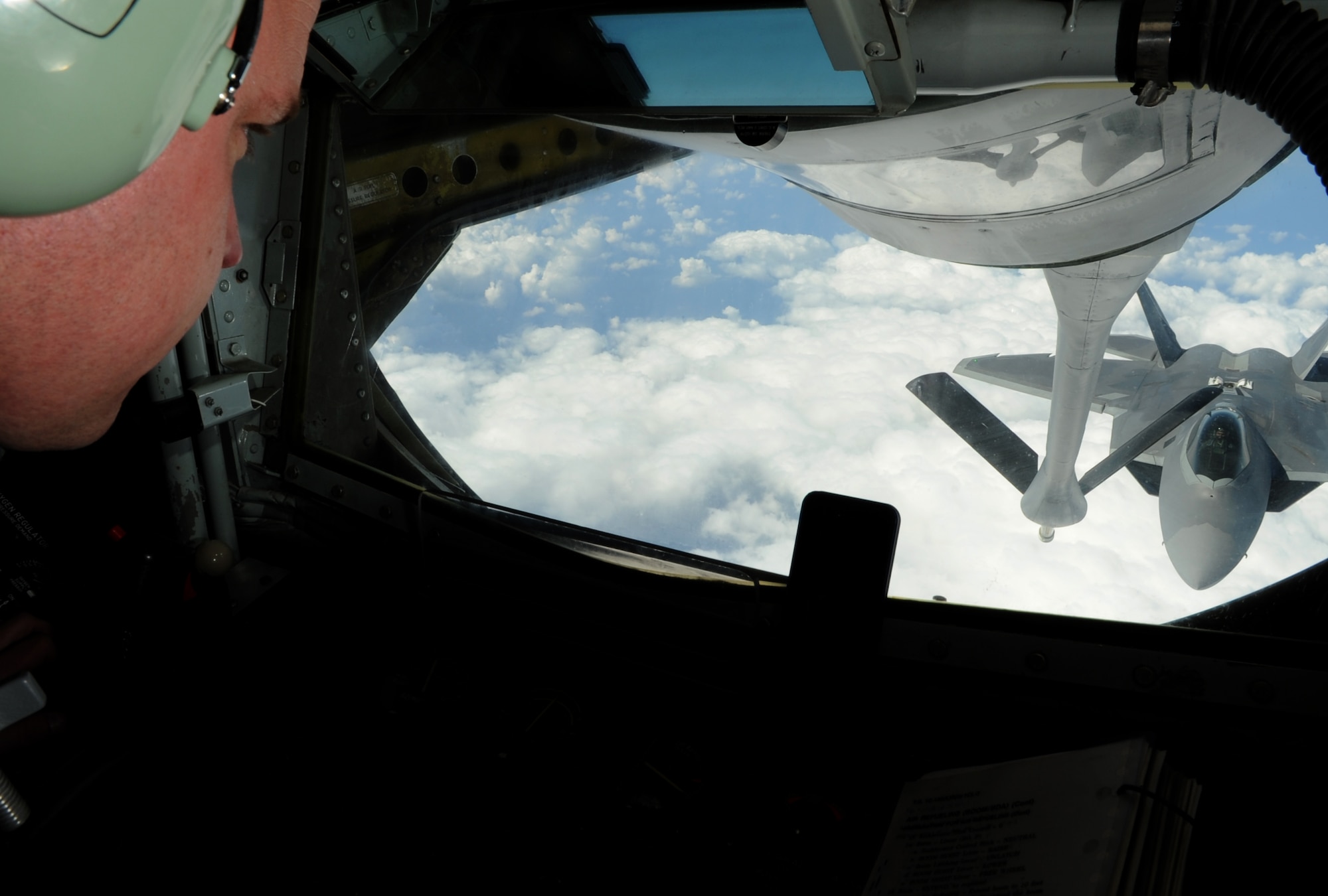 U.S. Air Force Tech. Sgt. Gabriel Ourso, 909th Air Refueling Squadron instructor boom operator, watches as an F-22 Raptor from Joint Base Langley-Eustis, Va., approaches the boom of a KC-135 Stratotanker stationed at Kadena Air Base, Japan, on Feb. 21, 2014. The 909th ARS "Young Tigers" are a crucial part in the 18th Wing mission, providing air refueling support to multiple aircraft on Kadena and regional allies. (U.S. Air Force photo by Airman 1st Class Keith James)
