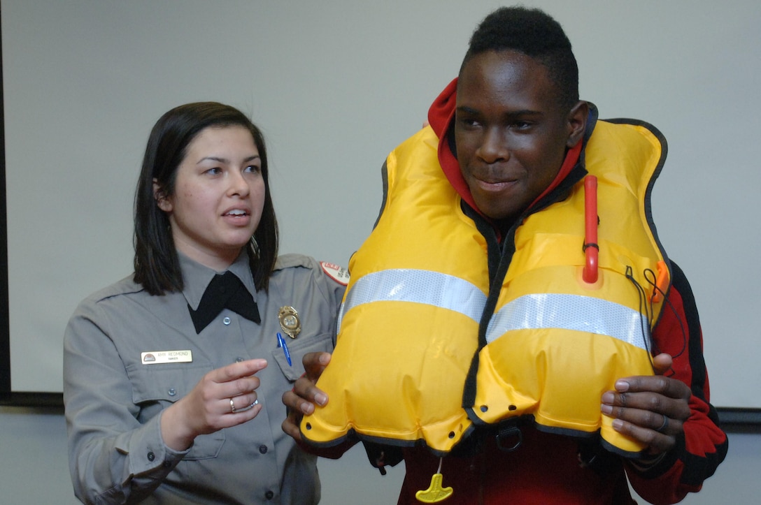 Old Hickory Lake Park Ranger Amy Redmond works with R. Evans, a freshman at Stratford STEM Magnet High School, to demonstrate how an inflatable life jacket is deployed during a field trip to Old Hickory Dam in Old Hickory, Tenn., Feb. 27, 2014.