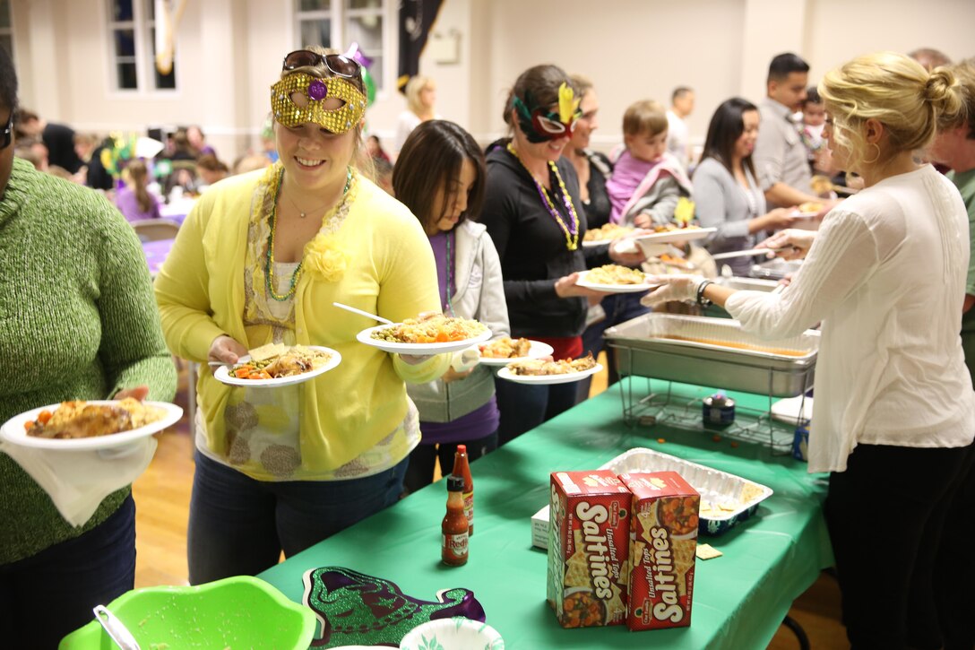 Family members dress up for the Mardi Gras-themed No Dough Dinner at the USO of North Carolina, Jacksonville Center, Feb. 24. The dinner is held at the end of the month for service members E-1 through E-6 who are struggling to make ends meet.
