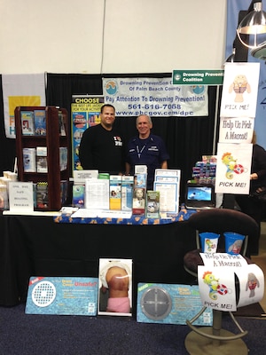 Adam Tarplee, natural resources program manager (left) and Chris Abernathy (right) of the U.S. Coast Guard Auxiliary partnered with Anna Stewart of the Drowning Prevention Coalition of Palm Beach County to educate the public about water safety at the South Florida Fair.