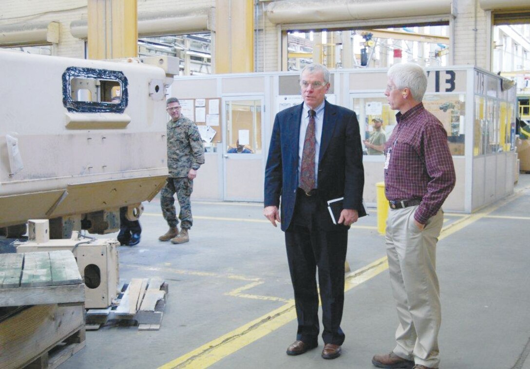 Tom Dee (center) deputy assistant Secretary of the Navy for Expeditionary Programs and Logistics Management, receives a tour of Marine Depot Maintenance Command led by Darren Jones (right) plant manager, Production Plant Albany, MDMC, during his visit to Marine Corps Logistics Command, Feb. 25. 