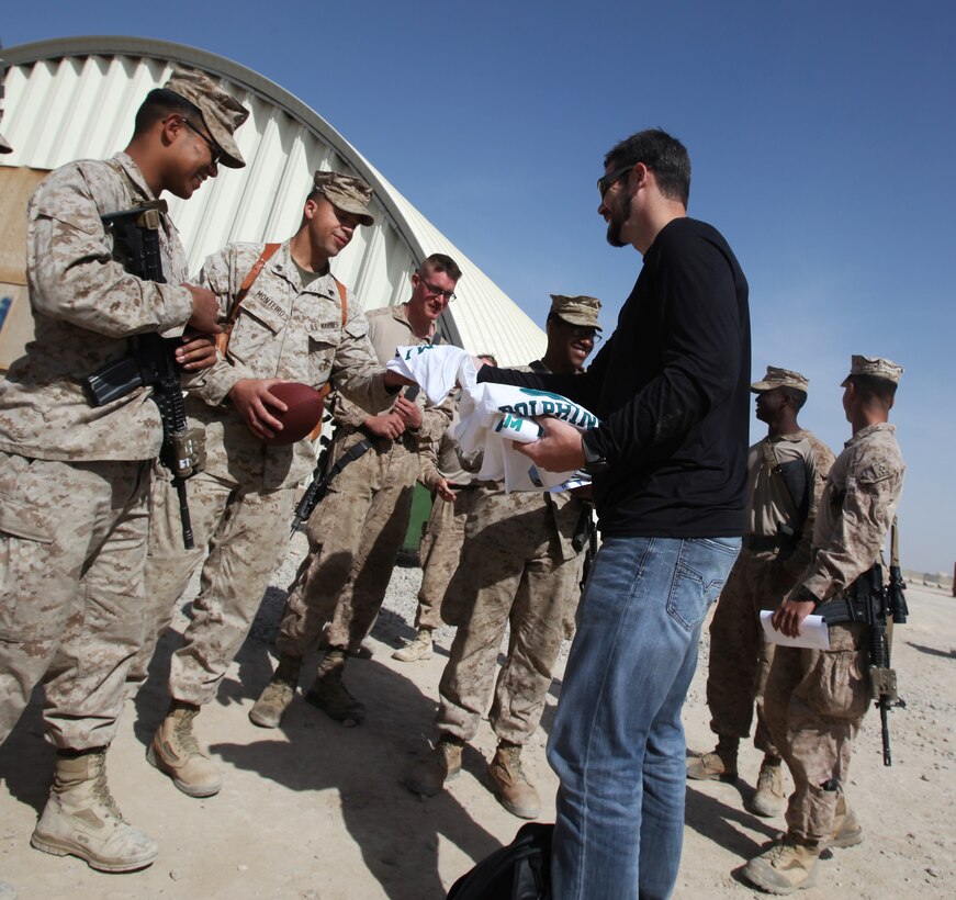 Miami Dolphins punter Brandon Fields hands out Miami Dolphins T-shirts and hats to Marines with 1st Battalion, 9th Marine Regiment, during a USO-sponsored tour to Camp Leatherneck, Afghanistan, March 3, 2014. Three NFL players volunteered for the tour to support troops serving in Operation Enduring Freedom. (U.S. Marine Corps photo by Cpl. Cody Haas/ Released)