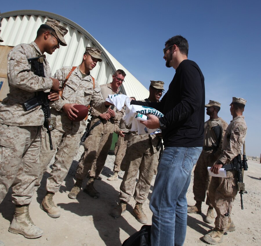 Miami Dolphins punter Brandon Fields hands out Miami Dolphins T-shirts and hats to Marines with 1st Battalion, 9th Marine Regiment, during a USO-sponsored tour to Camp Leatherneck, Afghanistan, March 3, 2014. Three NFL players volunteered for the tour to support troops serving in Operation Enduring Freedom. (U.S. Marine Corps photo by Cpl. Cody Haas/ Released)