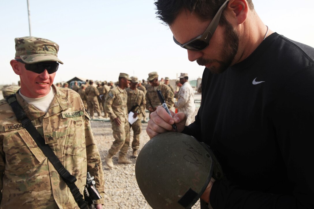 Miami Dolphins punter Brandon Fields signs a helmet for a soldier with Regional Command (Southwest) during a USO-sponsored tour to Camp Leatherneck, Afghanistan, March 3, 2014. Three NFL players volunteered for the tour to support troops serving in Operation Enduring Freedom. (U.S. Marine Corps photo by Cpl. Cody Haas/ Released)