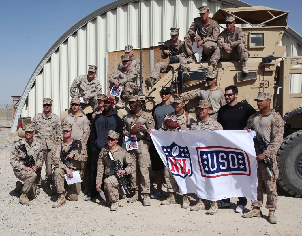 Washington Redskins wide receiver Pierre Garcon, left-center, New Orleans Saints tight end Jimmy Graham, center, and Miami Dolphins punter Brandon Fields, right, pose for a photo with Marines from 1st Battalion, 9th Marine Regiment, during a USO-sponsored tour to Camp Leatherneck, Afghanistan, March 3, 2014. Three NFL players volunteered for the tour to support troops serving in Operation Enduring Freedom. (U.S. Marine Corps photo by Cpl. Cody Haas/ Released)