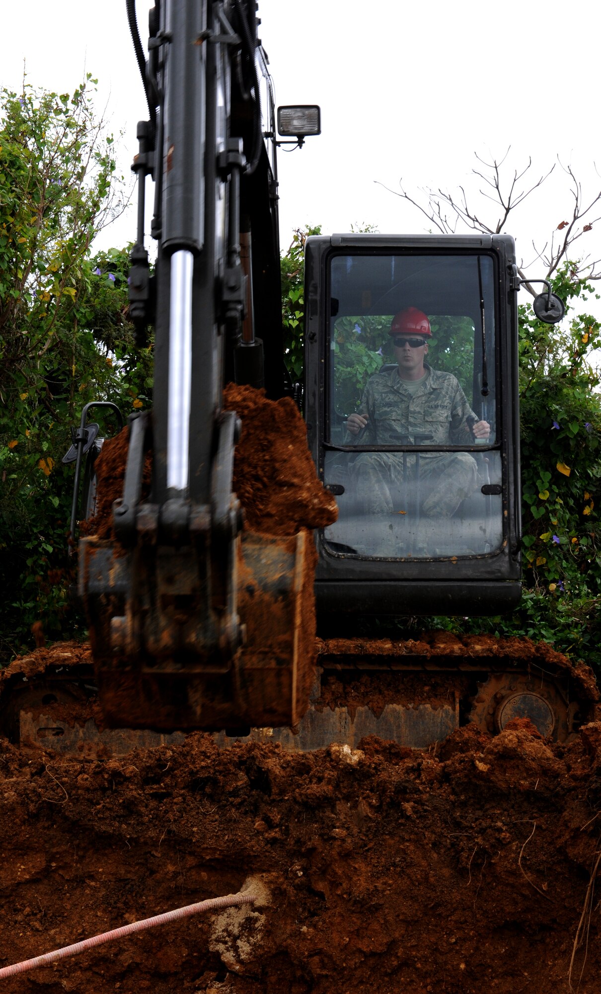 U.S. Air Force Staff Sgt. Justin Baker, 18th Civil Engineer Squadron heavy equipment operator, uses an excavator to dig up a main water line which recently broke on Kadena Air Base, Japan, Mar. 5, 2014. After losing more than five million gallons of water in six hours, the members were able to find the break and work to resolve the problem by digging around the pipe to repair the broken line, ensuring Kadena's water supply hadn't ran out. (U.S. Air Force photo by Airman 1st Class Keith James)