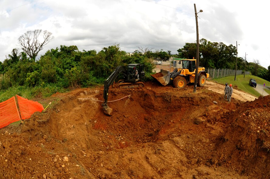 Members of the 18th Civil Engineering Squadron use an excavator and front end loader to dig up a main water line that recently broke on Kadena Air Base, Japan, March 5, 2014. After losing more than five million gallons of water in six hours, the members were able to find the break and work to resolve the problem by digging around the pipe to repair the broken line, ensuring Kadena's water supply hadn't ran out. (U.S. Air Force photo by Airman 1st Class Keith James)