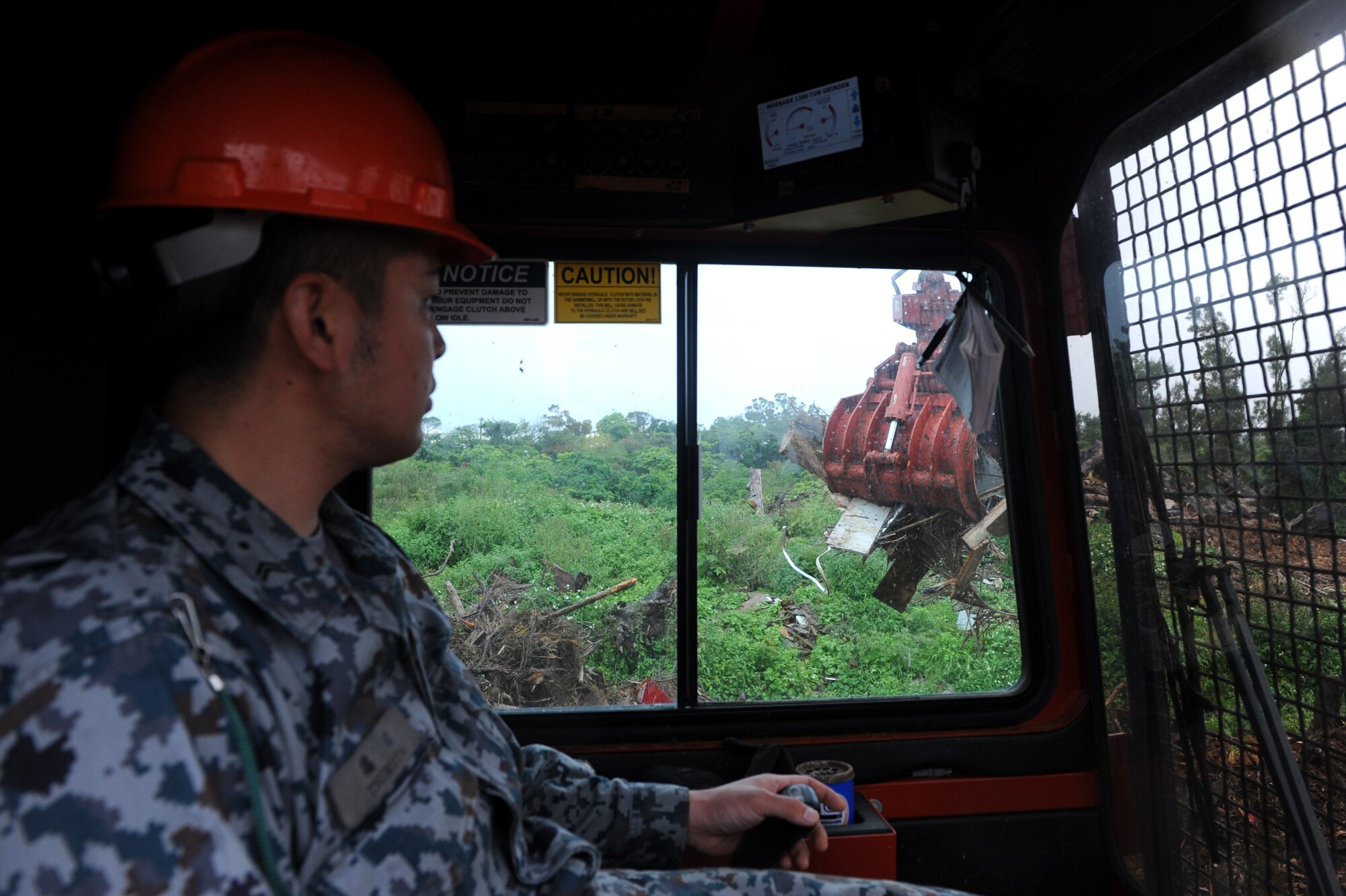 Japan Air Self-Defense Force Tech. Sgt. Tatsuya Tsuruta, civil engineer construction worker, operates a Morbark Tub Grinder on Kadena Air Base, Japan, March 4, 2014. This machine grinds any wood debris left over from typhoons or construction to create mulch. (U.S. Air Force photo by Airman 1st Class Hailey R. Staker)