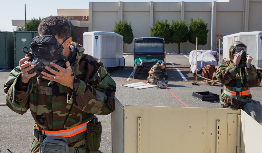 Airmen from the 374th Civil Engineer Squadron don their gas masks during a Samurai Readiness Inspection at Yokota Air Base, Japan, March 6, 2014. The readiness inspection was designed to evaluate areas such as rapid mobility response to simulated contingencies and providing airlift support to military and non-combatant evacuation. (U.S. Air Force photo by Osakabe Yasuo/Released) 