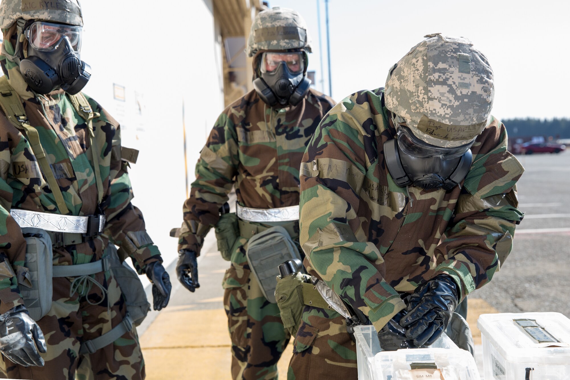 Tech. Sgt. Zachariah Edwards, right, 374th Maintenance Squadron, demonstrates the decontamination process during a Samurai Readiness Inspection at Yokota Air Base, Japan, March 6, 2014. The Airmen completed a Post Attack Reconnaissance sweep, which required them to complete a simulated decontamination of their equipment. (U.S. Air Force photo by Osakabe Yasuo/Released)