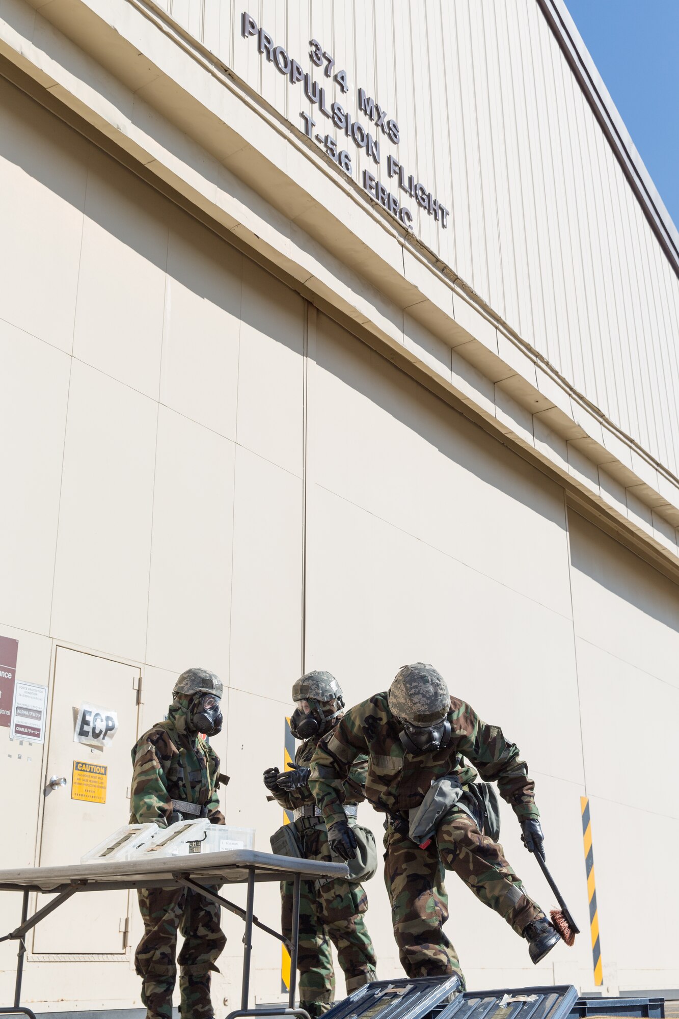 Airmen from the 374th Maintenance Squadron work together to complete the decontamination process during a Samurai Readiness Inspection at Yokota Air Base, Japan, March 6, 2014. The Airmen completed a Post Attack Reconnaissance sweep, which required them to complete a simulated decontamination of their equipment. (U.S. Air Force photo by Osakabe Yasuo/Released)  