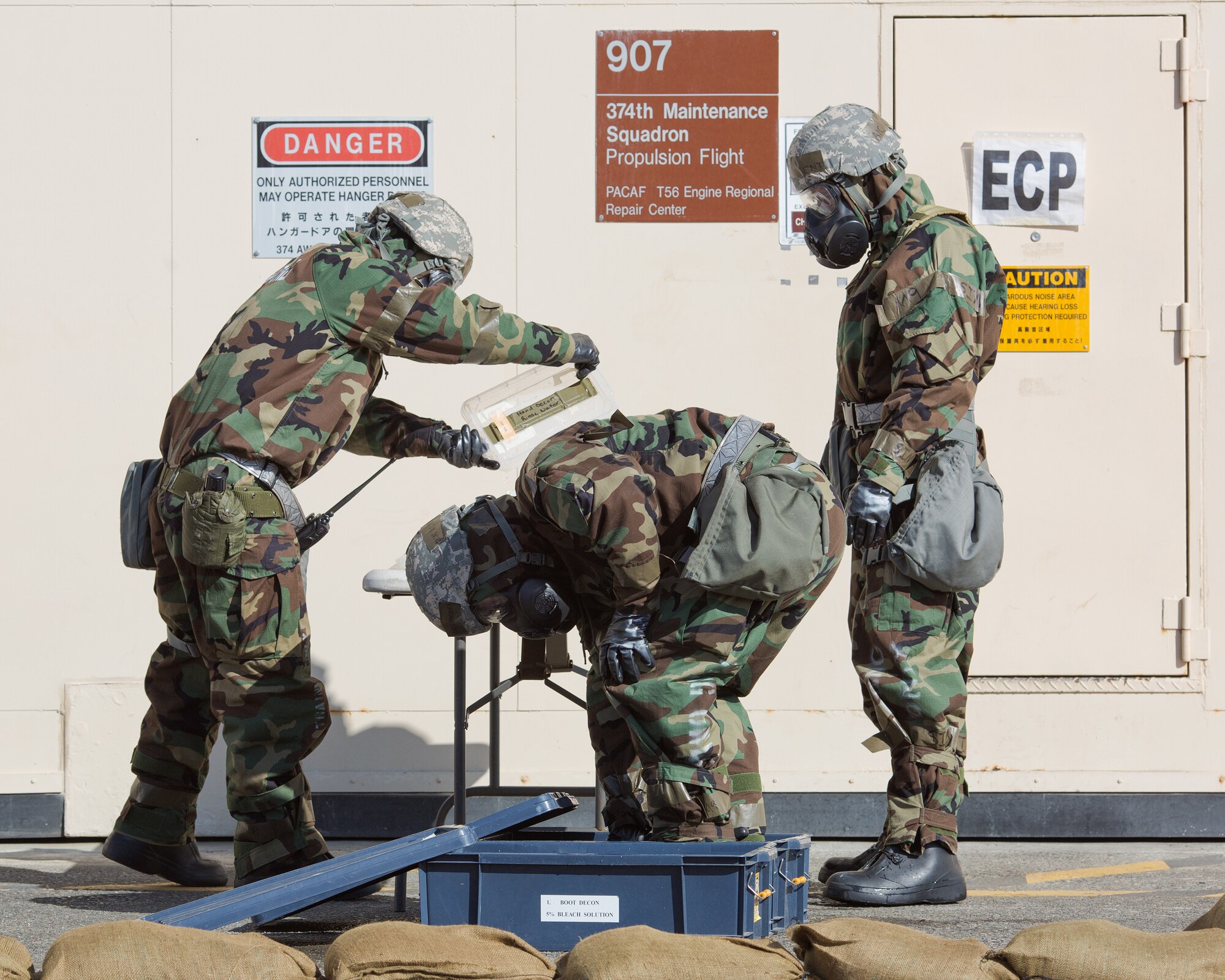 Airmen from the 374th Maintenance Squadron work together to complete the decontamination process during a Samurai Readiness Inspection at Yokota Air Base, Japan, March 6, 2014. The Airmen completed a Post Attack Reconnaissance sweep, which required them to complete a simulated decontamination of their equipment. (U.S. Air Force photo by Osakabe Yasuo/Released)   