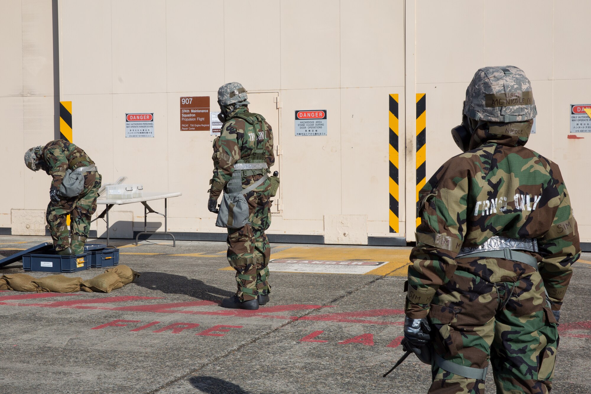 Airmen from the 374th Maintenance Squadron complete the decontamination process during a Samurai Readiness Inspection at Yokota Air Base, Japan, March 6, 2014. The Airmen completed a Post Attack Reconnaissance sweep, which required them to complete a simulated decontamination of their equipment. (U.S. Air Force photo by Osakabe Yasuo/Released)   