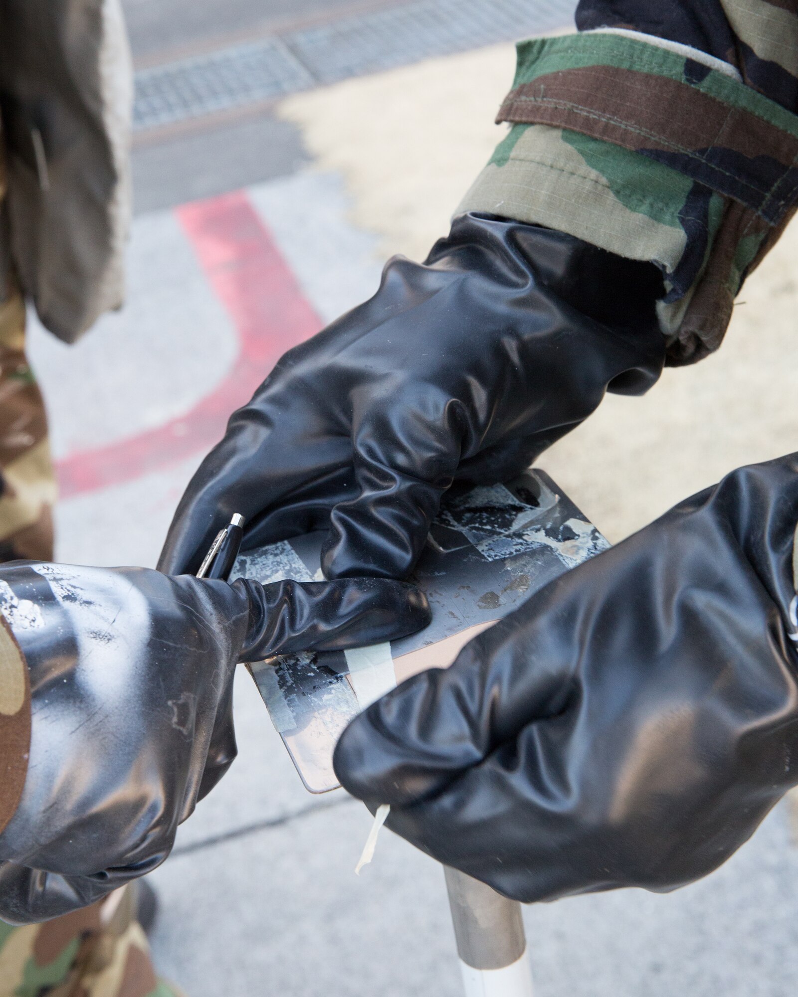 Airmen from the 374th Maintenance Squadron replace simulated M-9 paper on a station during a Samurai Readiness Inspection at Yokota Air Base, Japan, March 6, 2014. The Airmen checked the paper for changes in color to determine if there are chemical agents in the air. (U.S. Air Force photo by Osakabe Yasuo/Released) 