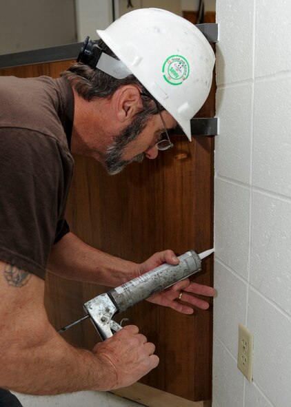 David Davis, Dean Kurtz Construction foreman, applies sealant on a wall in the front office of the Bellamy Fitness Center at Ellsworth Air Force Base, S.D., Feb. 25, 2014. Renovations to the front office area include a security monitoring system, new floors and new desks. (U.S. Air Force photo by Senior Airman Anania Tekurio/Released)