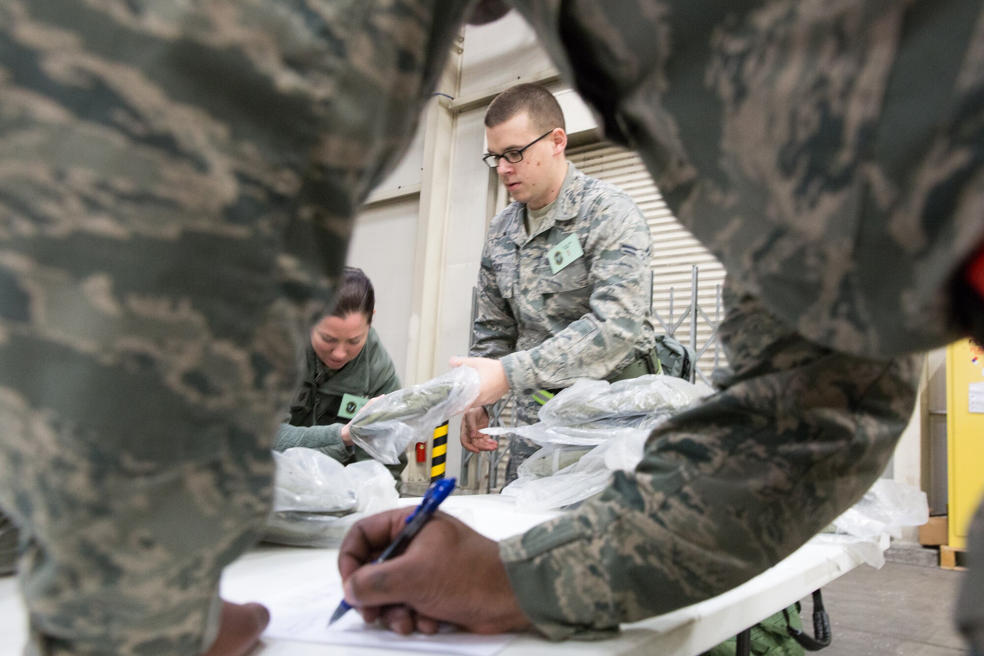 Members from the 374th Comptroller Squadron receive individual protective equipment during a Samurai Readiness Inspection at Yokota Air Base, Japan, March 5, 2014. Yokota Airmen conducted a week-long exercise in order to test and improve its readiness functions. (U.S. Air Force photo by Osakabe Yasuo/Released) 