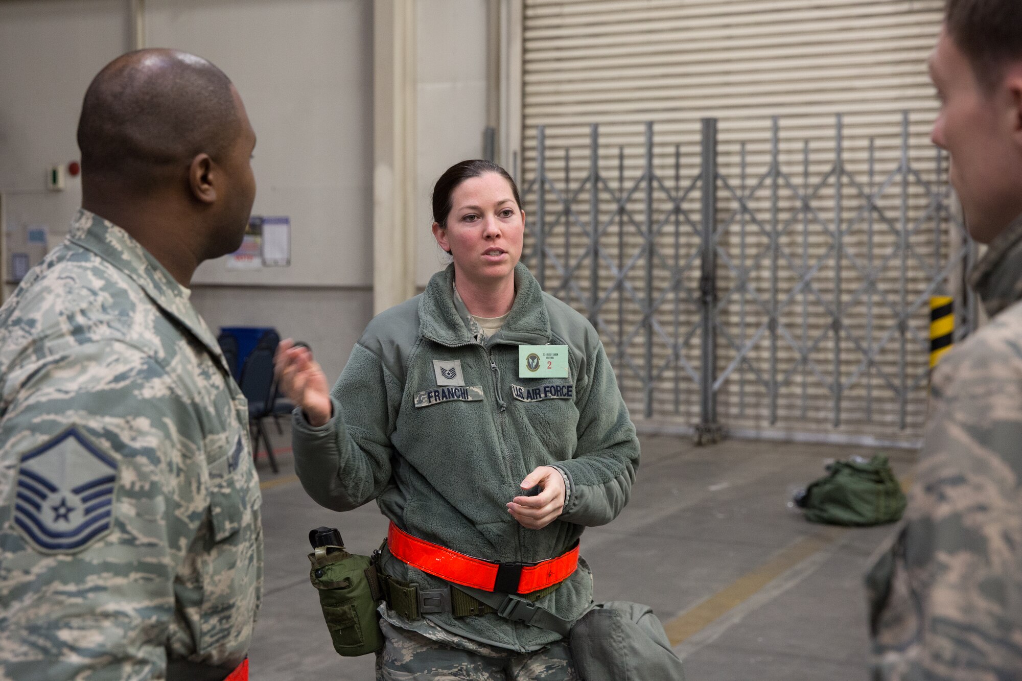 Tech. Sgt. Christine Franchi, center, 374th Comptroller Squadron, talks to members from the 374th Logistics Readiness Squadron before receiving individual protective equipment during a Samurai Readiness Inspection at Yokota Air Base, Japan, March 5, 2014. During the inspection, maintainers, aircrew and base support functions must synchronize their efforts to complete a series of simulated deployment tasks in order to demonstrate their ability to respond to real-world crises. (U.S. Air Force photo by Osakabe Yasuo/Released)