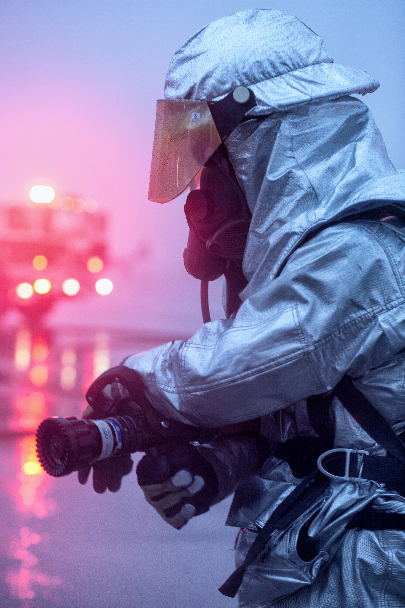 A firefighter from the 374th Civil Engineer Squadron scans the area after battling a simulated vehicle explosion during a Samurai Readiness Inspection at Yokota Air Base, Japan, March 5, 2014. The inspection was designed to evaluate Yokota’s ability to provide airlift capabilities while responding to a variety of contingency response scenarios. (U.S. Air Force photo by Osakabe Yasuo/Released)