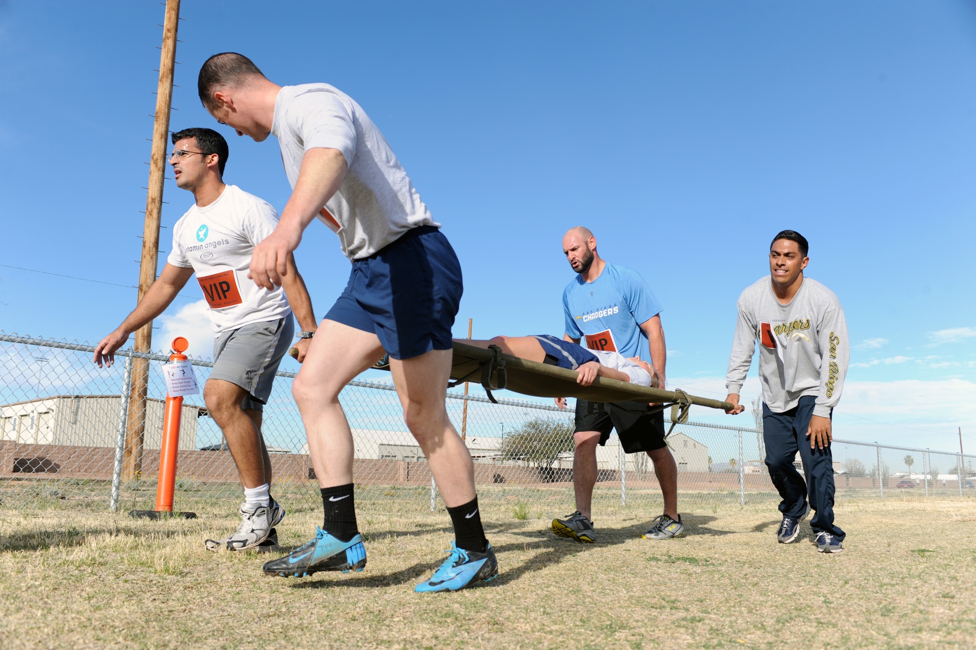 Members of ?Team VIP?, including Jarret Johnson, linebacker for the San Diego Chargers of the National Football League, carry a teammate on a litter during a Comprehensive Airmen Fitness Day competition at Davis-Monthan Air Force Base, Ariz., March 3, 2014.  D-M recognized the physical pillar of CAF which is defined as performing and excelling in physical activities that require aerobic fitness, endurance, strength, flexibility and body composition derived through exercise, nutrition and training.  (U.S. Air Force Photo by Airman 1st Class Chris Massey)
