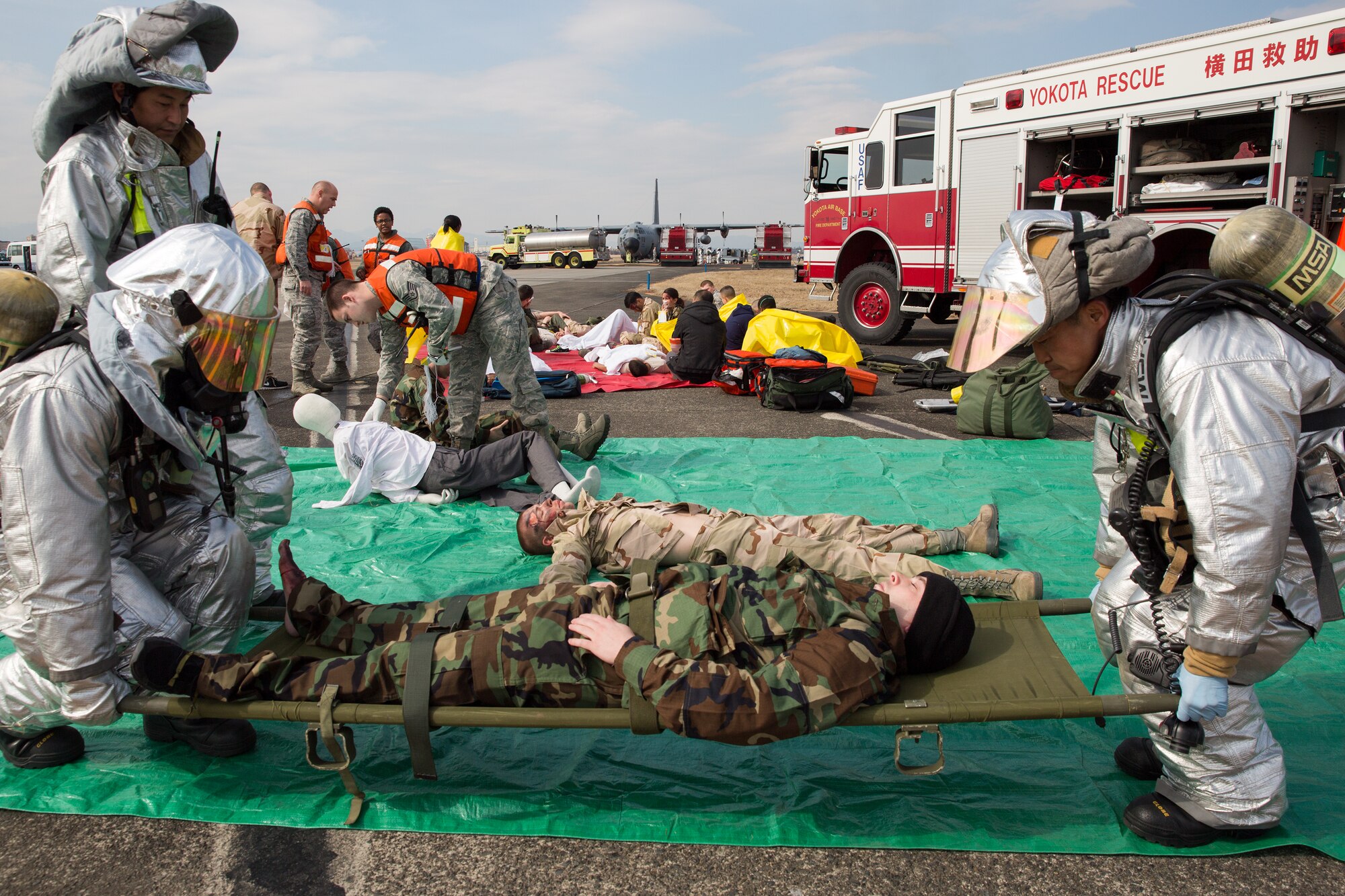 Yokota firefighters transport a simulated victim to a triage area during a Samurai Readiness Inspection at Yokota Air Base, Japan, March 4, 2014. The readiness inspection was designed to evaluate areas such as rapid mobility response to simulated contingencies and providing airlift support to military and non-combatant evacuation. (U.S. Air Force photo by Osakabe Yasuo/Released)