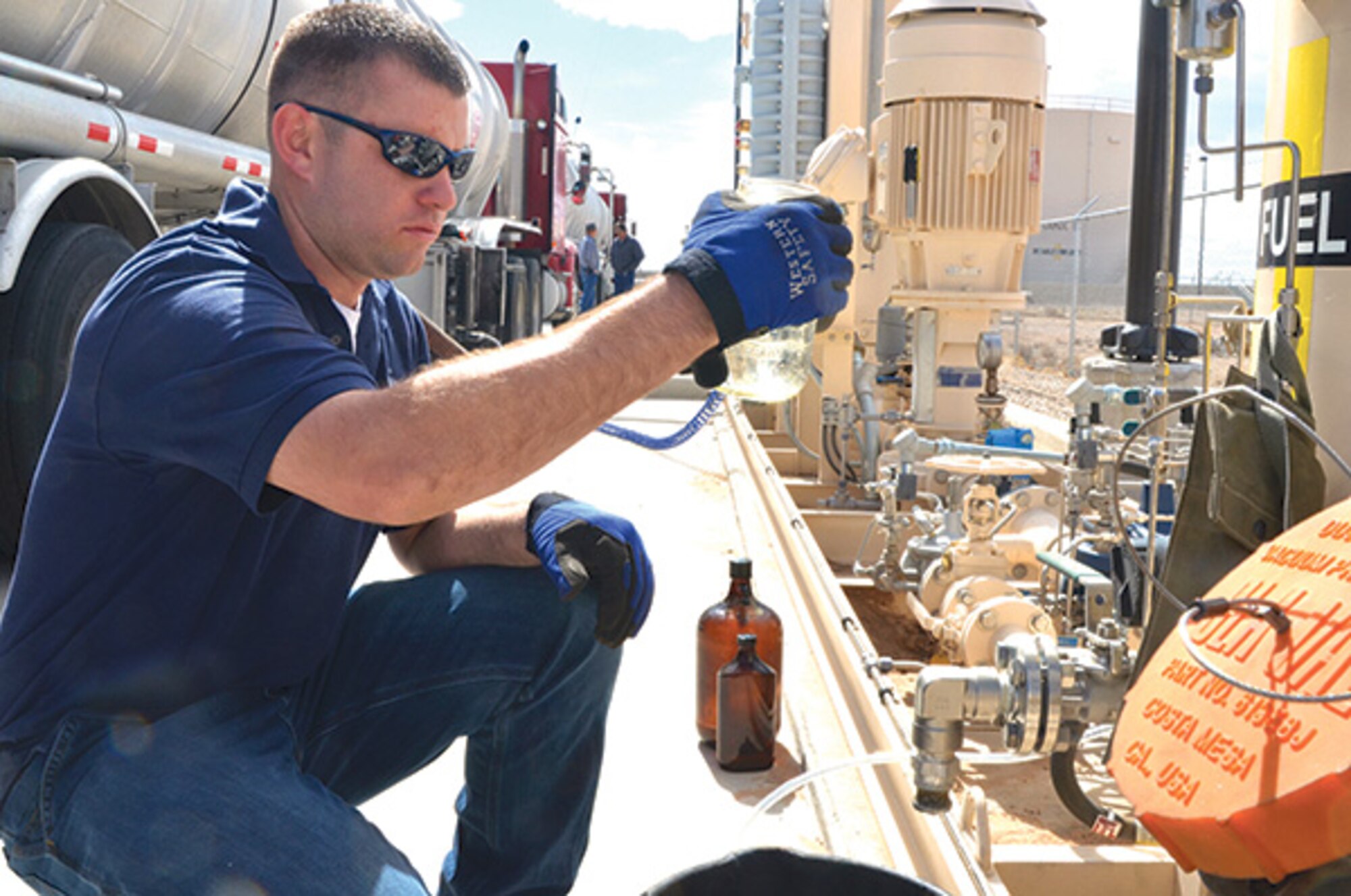 Nathan Marquez, a fuels distribution system operator, examines a sample of jet fuel delivered to Kirtland. (Photo by Lee Ross)