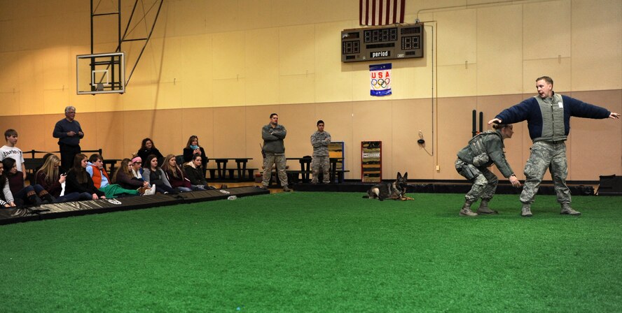 More than 50 Cascade County high school students watch as members of the 341st Security Forces Squadron military working dog section perform a K-9 demonstration at the Malmstrom Fitness Center on Feb. 26. Students had an opportunity to tour Malmstrom Air Force Base and learn about the mission as part of a Leadership High School tour. (U.S. Air Force photo/Senior Airman Katrina Heikkinen)