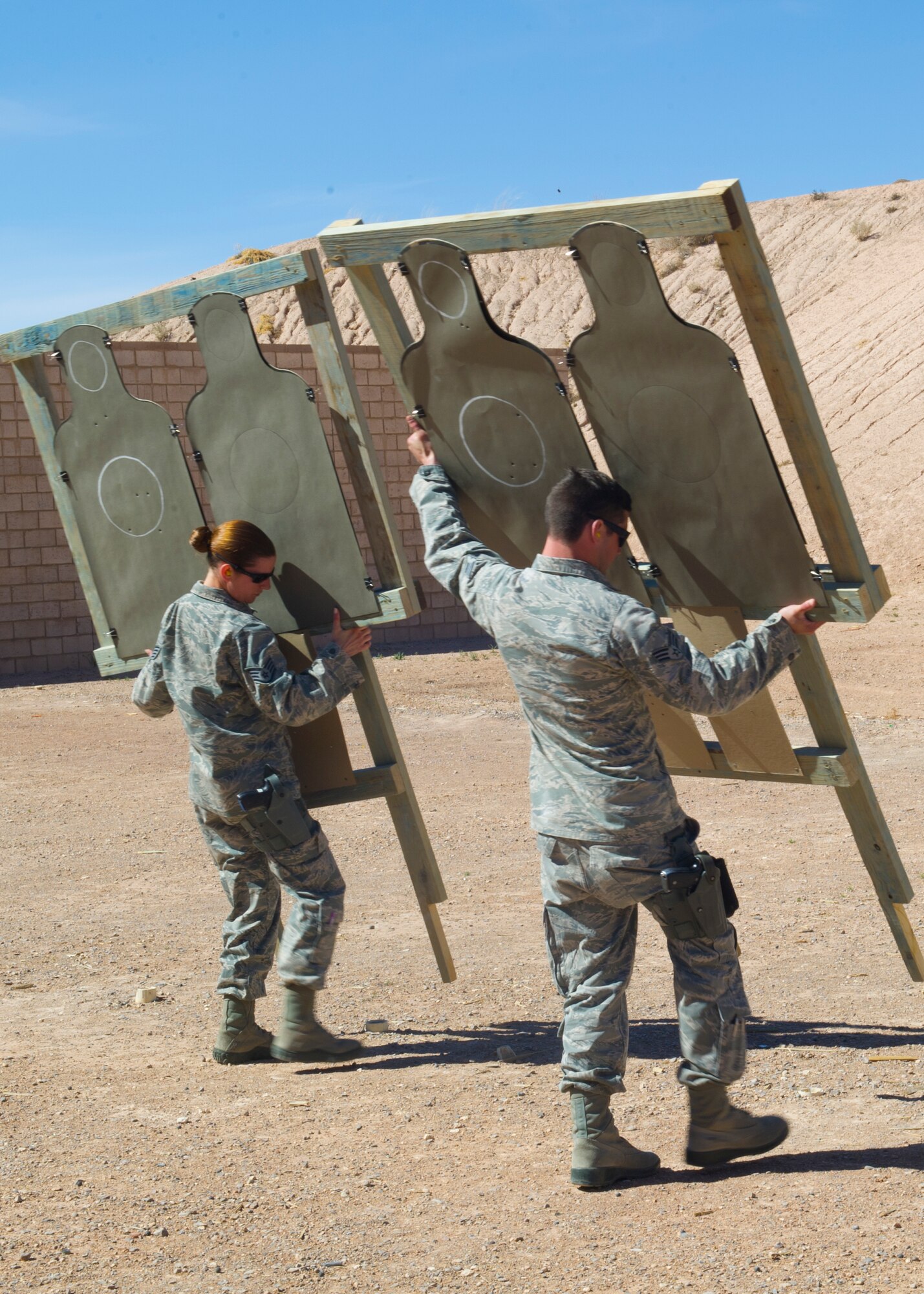 Members from the 49th Security Forces squadron prepare their targets to begin their weapon’s qualification course at Holloman Air Force Base, N.M., March 5. Four Security Forces members took the M-9 pistol Air Force Qualification Course at Holloman’s Combat Arms Training and Maintenance site. This course is designed to help Airmen become mission effective as well as combat ready. (U.S. Air Force photo by Airman 1st Class Leah Ferrante/Released)   