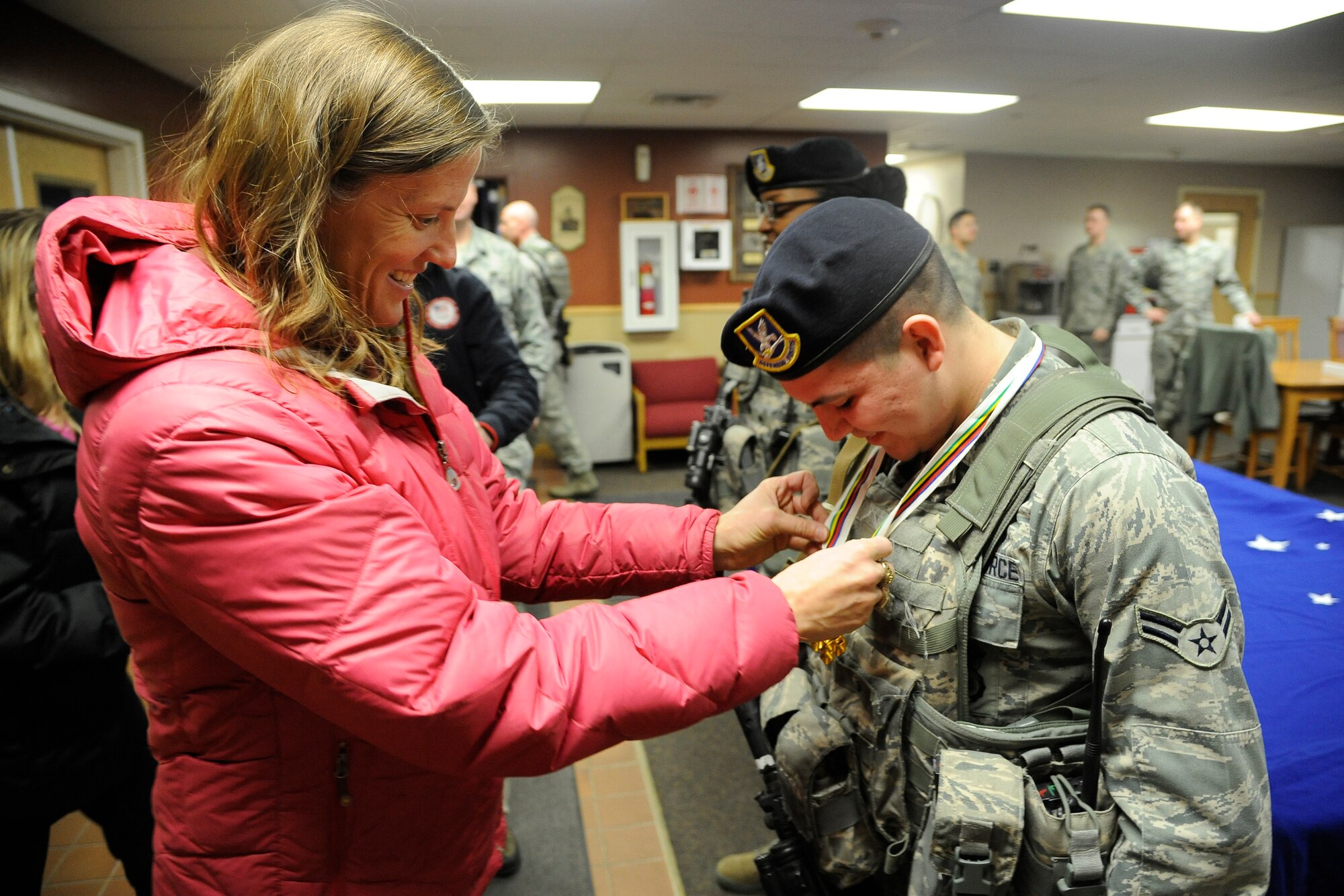 Anne Battelle, former U.S. Olympic mogul skier, places a medal she won during the Goodwill Games in 2000 around the neck of Airman 1st Class Michael Carrete, 341st Missile Security Forces Squadron member, during a visit to his duty station Feb. 27.  During the visit, security forces members had the opportunity to speak with Battelle and another Olympic athlete, Erin Simmons-Nemec, and ask them a variety of questions about their Olympic careers and life after competing. (U.S. Air Force photo/Airman 1st Class Collin Schmidt)
