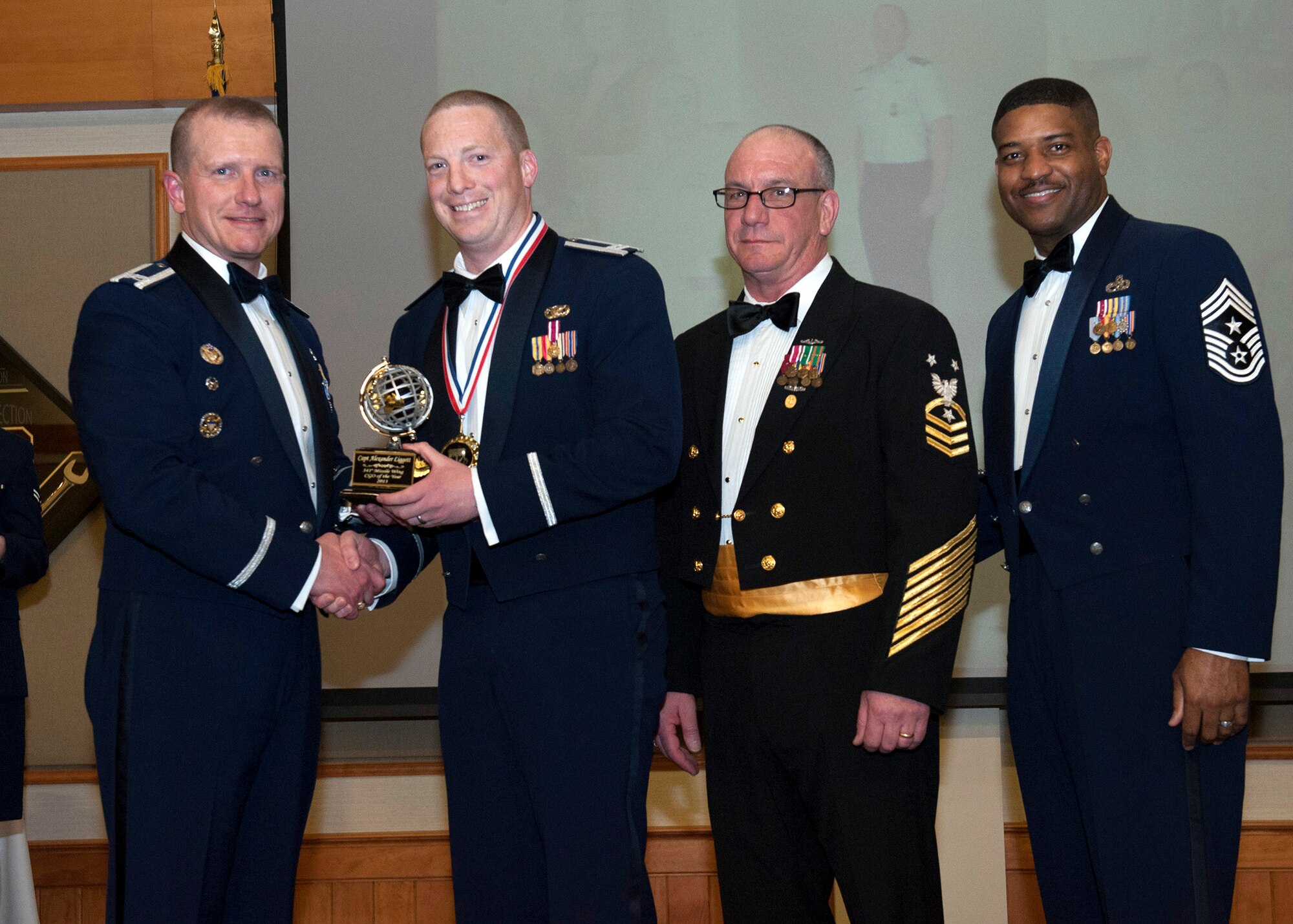 Capt. Alexander Liggett, 341st Missile Security Forces Squadron operations officer (center left), poses for a photograph with Col. Robert Stanley, 341st Missile Wing commander (left), Command Master Chief Kevin Staub, Submarine Group Nine commander (center right), and Chief Master Sgt. Phillip Easton, 341st MW command chief, after receiving the Company Grade Officer of the Year award at the 2013 Annual Awards Banquet on Feb. 28. The award winners were selected based on their work ethic, attention to detail, leadership and an all-around encompassment of the Air Force core values. (U.S. Air Force photo/John Turner)

