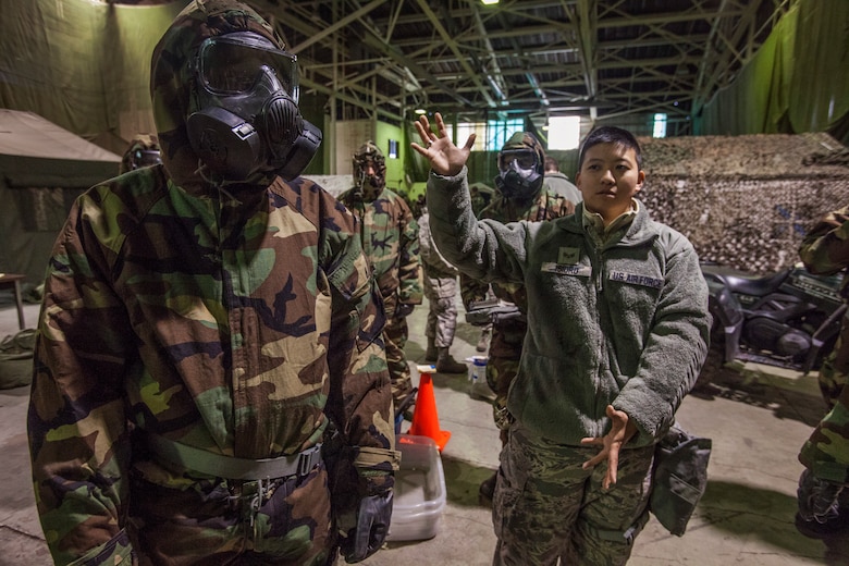Senior Airman Melissa C. Isidro, right, explains the proper way Mission Oriented Protective Posture gear should be worn as Airmen from the 108th Wing, New Jersey Air National Guard, brush up on their chemical, biological, radiological and nuclear; self-aid buddy care; post attack reconnaissance and disassembling and reassembling Beretta M9 pistol and M16 rifle skills during the Wing’s Ability to Survive and Operate Rodeo at Joint Base McGuire-Dix-Lakehurst, N.J. Feb. 9, 2014. The Wing-level evaluation shows what training areas need more focus. ATSO is used by Airmen who are deploying or preparing for exercises or inspections. These skills make up the foundation necessary for all Airmen to function effectively in hostile environments. (U.S. Air National Guard photo by Master Sgt. Mark C. Olsen/Released)