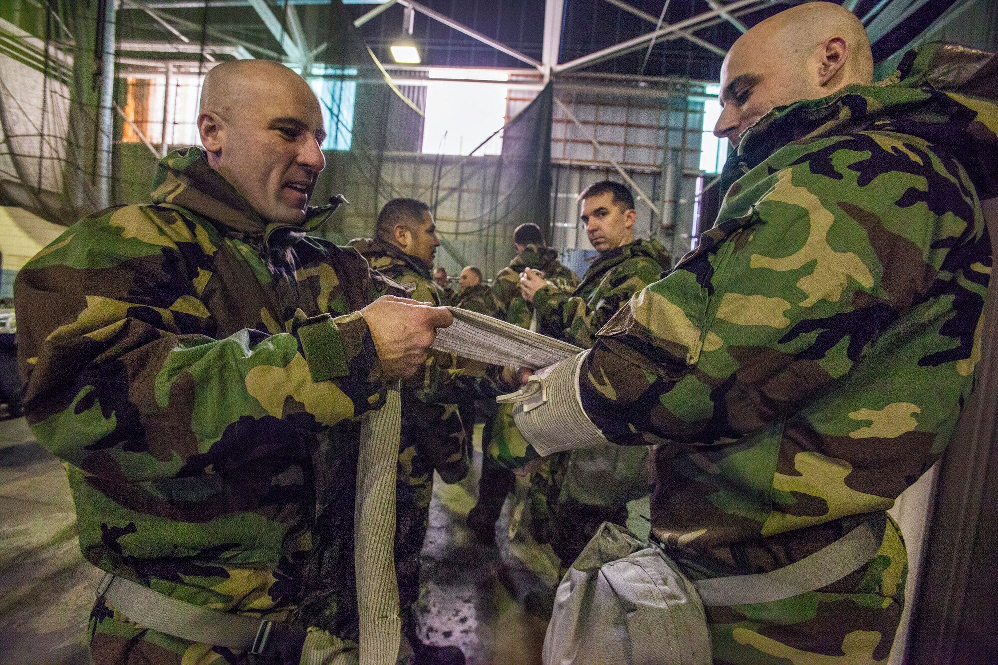 Tech. Sgt. Richard L. Coppinger, left, applies an Israeli Bandage on Staff Sgt. Joseph C. Cox as Airmen from the 108th Wing, New Jersey Air National Guard, brush up on their chemical, biological, radiological and nuclear; self-aid buddy care; post attack reconnaissance and disassembling and reassembling Beretta M9 pistol and M16 rifle skills during the Wing’s Ability to Survive and Operate Rodeo at Joint Base McGuire-Dix-Lakehurst, N.J. Feb. 9, 2014. The Wing-level evaluation shows what training areas need more focus. ATSO is used by Airmen who are deploying or preparing for exercises or inspections. These skills make up the foundation necessary for all Airmen to function effectively in hostile environments. (U.S. Air National Guard photo by Master Sgt. Mark C. Olsen/Released)