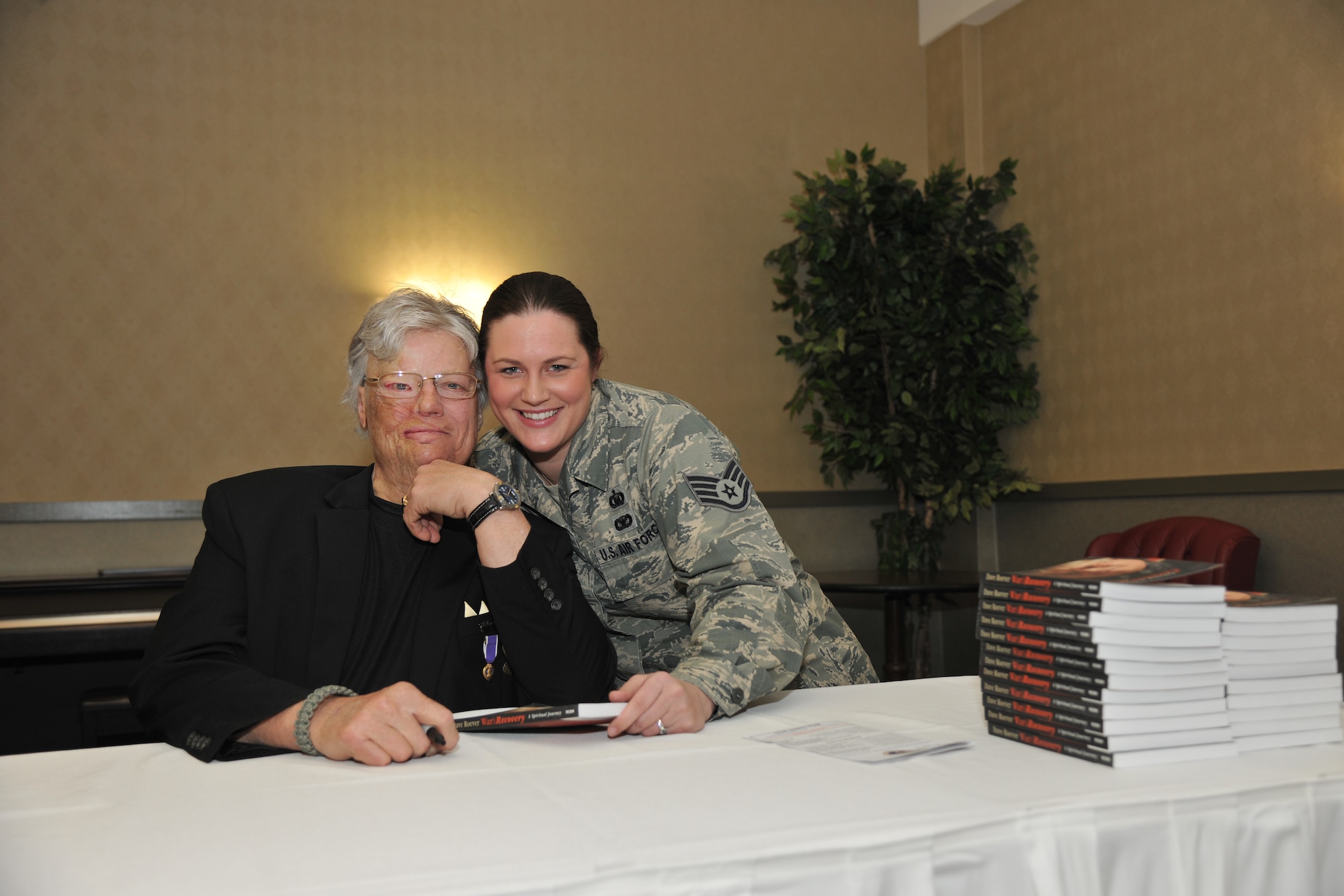Staff Sgt. Nikki Webb, NCO-in-charge of chapel operations for the 319th Air Base Wing Chapel (right), visits with inspirational speaker and disabled Vietnam War veteran Dave Roever Feb. 6, 2014, at the National Prayer Luncheon on Grand Forks Air Force Base, N.D. Webb was recently named the Outstanding Chaplain Assistant NCO of the Year for Air Mobility Command after having already been named NCO of the Year for the 319th Air Base Wing Staff Agencies, and two-time NCO of the Quarter. (U.S. Air Force photo/Senior Airman Xavier Navarro)