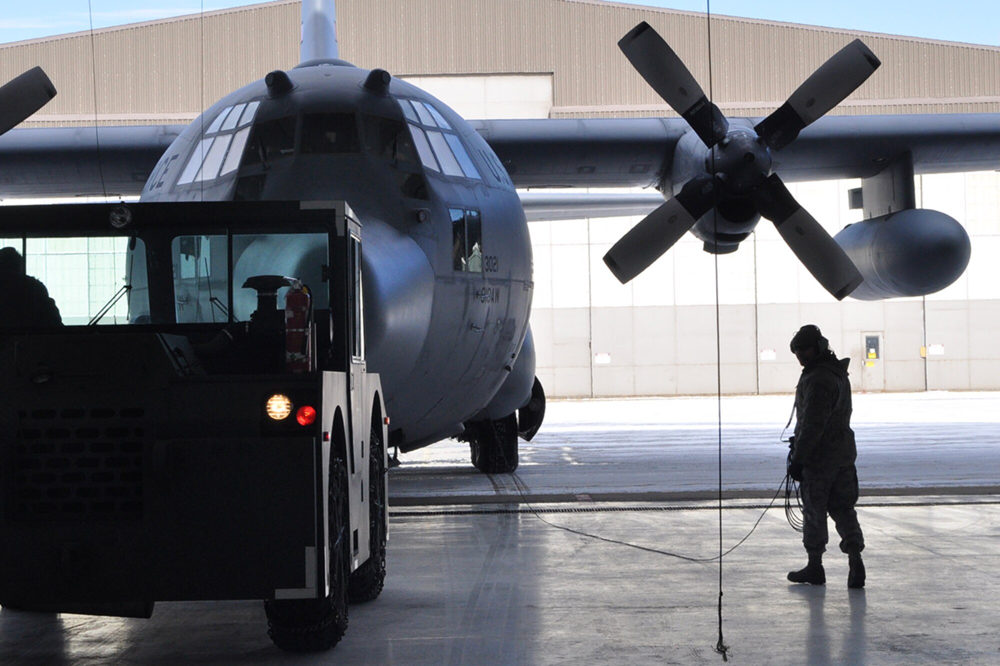 YOUNGSTOWN AIR RESERVE STATION, Ohio – Air Force Reserve Master Sgt. Sam Phillippi, crew chief of 910th Airlift Wing Tail 3021, a C-130 Hercules cargo aircraft, looks back into a maintenance hangar here, March 3, 2014. A tow motor is pushing his aircraft, Tail 3021, onto the air station flightline as it is prepared to depart here for the final time. The C-130 is being transferred to Little Rock Air Force Base, Ark. as part of recent Air Force structure changes. The departure of 3021 from YARS leaves the 910th with eight primary C-130 aircraft and one back up aircraft assigned to the unit. U.S. Air Force photo by Master Sgt. Bob Barko Jr.