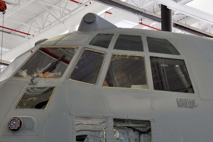 YOUNGSTOWN AIR RESERVE STATION, Ohio – An Air Force Reserve flight engineer peers from the flight deck windows of 910th Airlift Wing Tail 3021, a C-130 Hercules cargo aircraft, in a maintenance hangar during flight preparations here, March 3, 2014. The aircraft is departing YARS for the final time prior to being transferred to Little Rock Air Force Base, Ark. as part of recent Air Force structure changes. The departure of 3021 from YARS leaves the 910th with eight primary C-130 aircraft and one back up aircraft assigned to the unit. U.S. Air Force photo by Master Sgt. Bob Barko Jr.