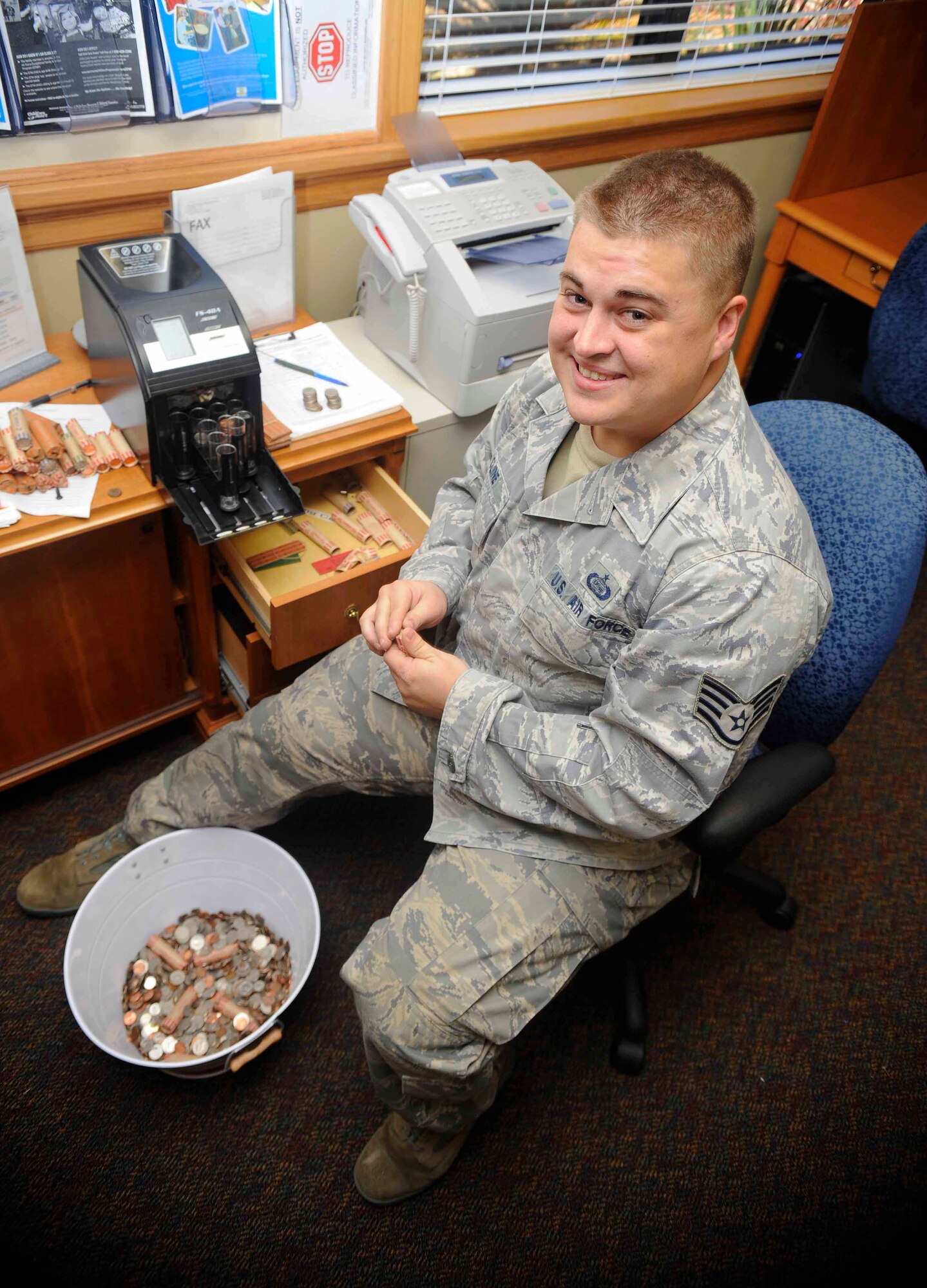 Staff Sgt. Benjamin Cline, 1st Special Operations Support Squadron intelligence readiness analyst, counts coins for the airman & family readiness center’s Military Saves Week contest on Hurlburt Field, Fla., Feb. 27, 2014. Cline won the “Change to Save” contest with $652.21. (U.S. Air Force photo/Airman 1st Class Andrea Posey)